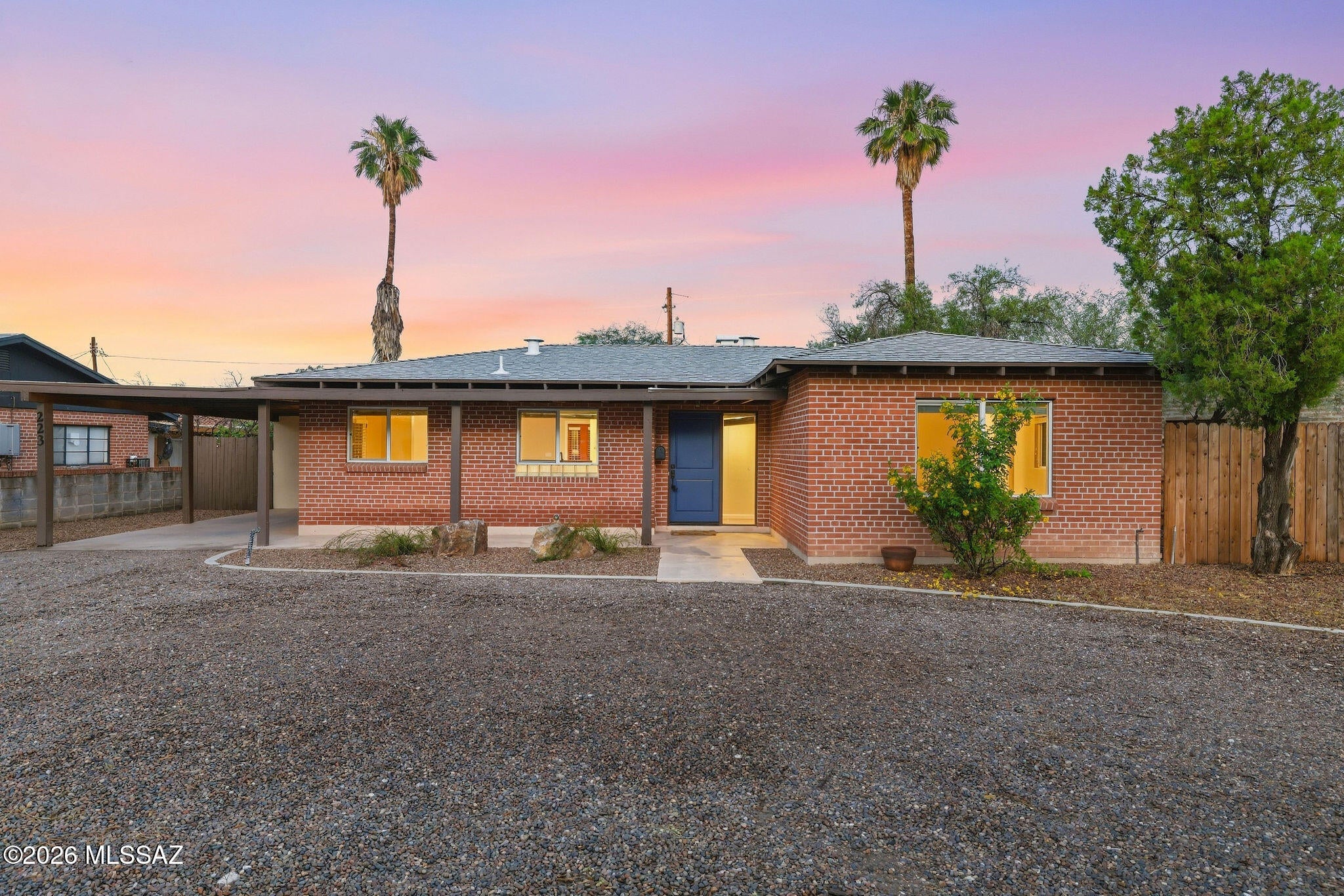 Timeless Tucson character meets thoughtful updates in this beautifully cared-for brick home in highly desirable Sam Hughes! Mature desert landscaping, a welcoming front porch, and classic curb appeal set the tone for a property that reflects genuine pride of ownership! Inside, high ceilings, warm-toned flooring, and an open layout create an inviting connection between the living, dining, and kitchen spaces.
The updated kitchen balances charm and functionality with crisp white cabinetry, glass-front accents, stainless steel appliances, a gas range, and generous counter space. A raised breakfast bar keeps the kitchen connected to the living area, making conversation and casual entertaining feel effortless! Two comfortable bedrooms and two tastefully updated bathrooms complement the home's appealing blend of character and everyday livability.
French doors lead to one of the home's most memorable spaces: an expansive, glass-enclosed Arizona room featuring a rich wood-plank ceiling, warm tile flooring, and a brick fireplace. Overlooking the backyard, this inviting retreat offers room to gather, unwind, or settle in with a favorite book. Outside, a pergola-covered flagstone patio, brick pathways, and mature trees create a welcoming setting for outdoor dining and relaxed Tucson evenings! Covered parking and a separate laundry and utility room add practical convenience.
With easy access to the University of Arizona, Banner-University Medical Center, Reid Park, and nearby dining and shopping, this home brings together the character of Sam Hughes with the convenience of central Tucson living. Solid brick construction, thoughtful improvements, and inviting indoor and outdoor spaces make this a home with lasting appeal. Welcome Home!