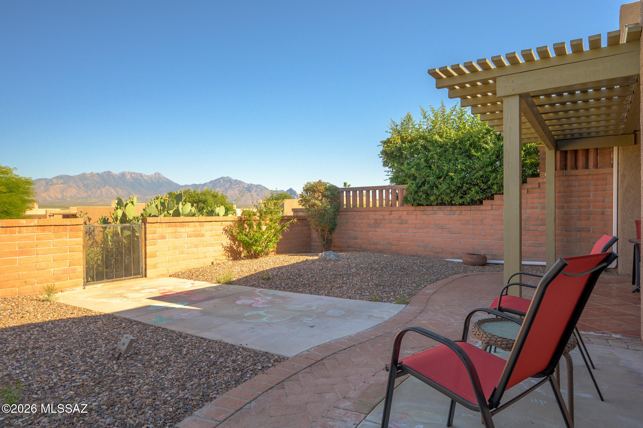 Welcome to a beautifully modernized townhouse designed for the active retiree seeking comfort, convenience, and breathtaking mountain views. Step inside to discover rich southwest-inspired diagonal tile flooring that flows gracefully throughout the entire home.  Impressive 12-foot ceilings, clerestory windows, and strategically placed skylights fill the home with abundant natural light, creating a warm and inviting atmosphere.  The stunning, fully updated kitchen is a chef's delight, featuring attractive hickory cabinets, granite countertops, and new stainless-steel appliances. You'll enjoy the views from the cozy dining area.  An elegant archway seamlessly connects the kitchen to the living area, encouraging conversation and gatherings with friends and family.  Retreat to a spacious primary suite large enough for a cozy sitting area and enjoy private access to your own secluded patio--perfect for morning coffee or quiet evening retreat. The versatile guest bedroom, equipped with a Murphy bed, easily transforms into an office, den, or creative space to suit your lifestyle needs.  Step outside to your east-facing patio, crafted with a low-maintenance aluminum ramada, where unobstructed Santa Rita Mountain views await. Start your days with breathtaking sunrises and unwind each evening as vibrant desert sunsets paint the sky with unique colors each evening. Nestled in a gated community, you'll enjoy a private pool exclusively for residents and full access to Green Valley Recreation's exceptional amenities.  This is an ideal Southern Arizona townhome for those ready to have a special winter get away or embrace an active and vibrant retirement.