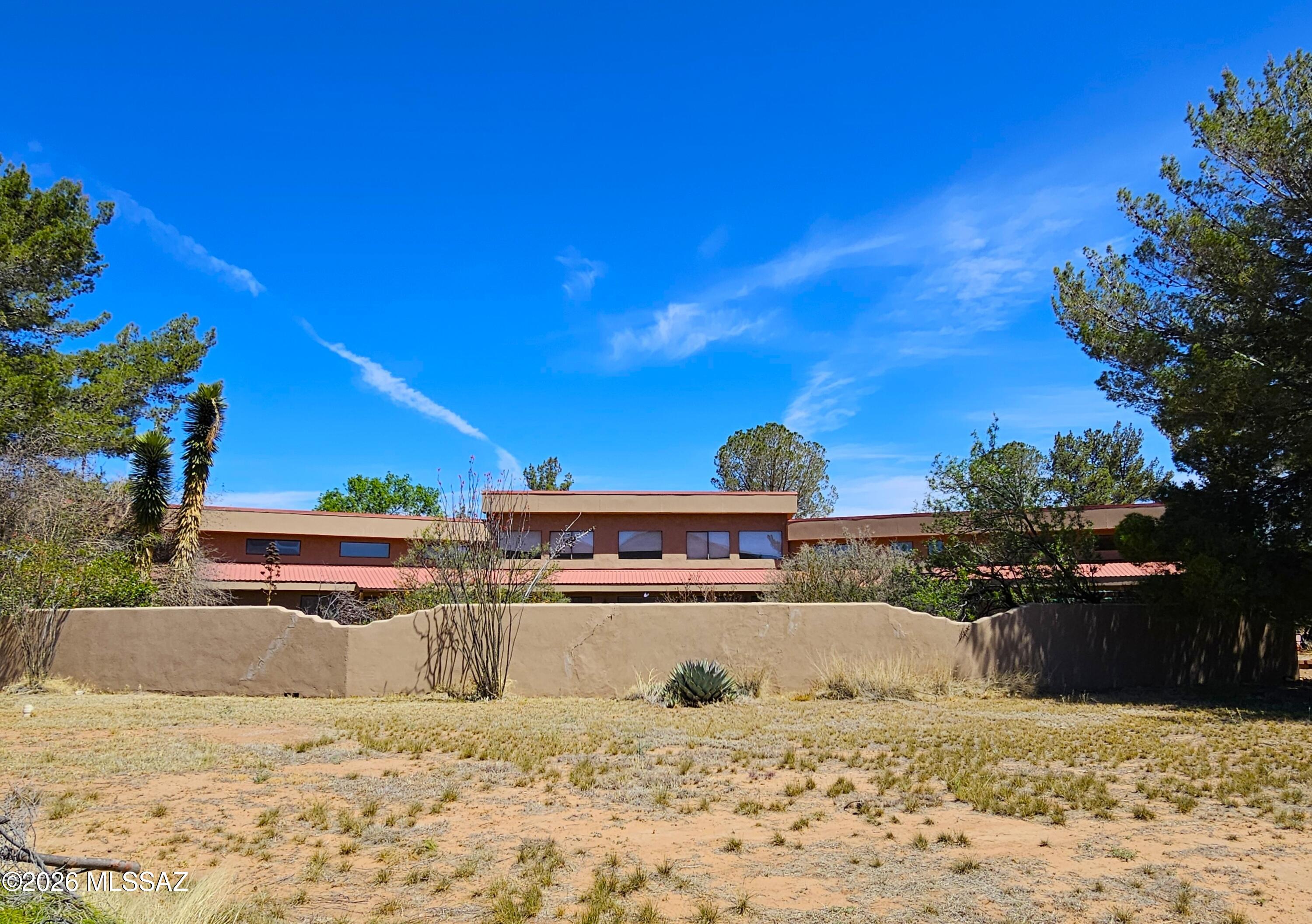 Nestled in the heart of Arizona wine country, this property offers breathtaking views and natural beauty in every direction. The home features a spacious living area with expansive windows designed to capture the stunning mountain scenery. Situated on more than 14 acres, there's plenty of room for horses and to enjoy the serene surroundings. A charming courtyard and separate outbuildings provide the perfect opportunity for a workshop, studio, or additional storage. Ideally located halfway between Huachuca City and Sonoita, this property offers privacy and convenience.
