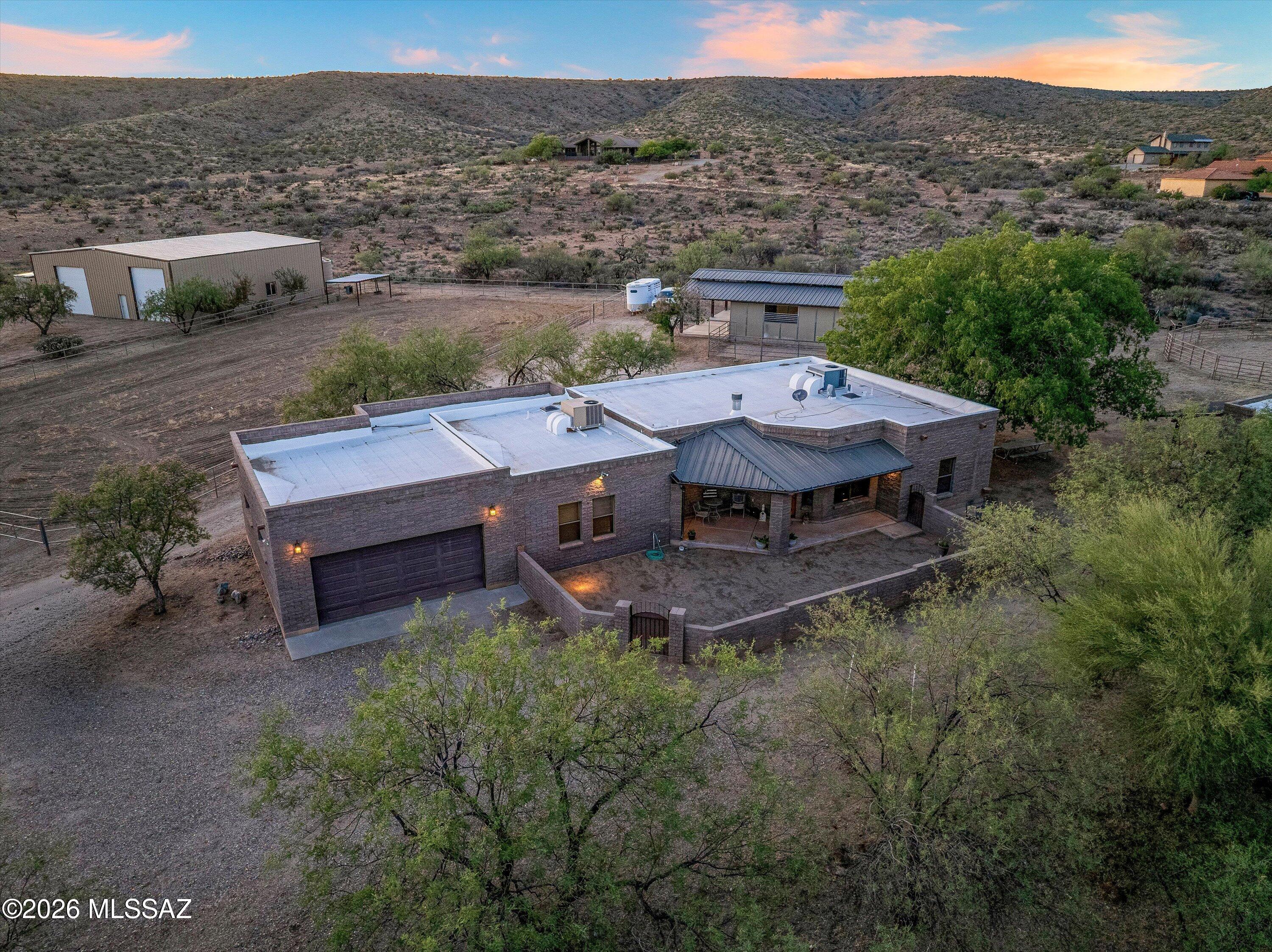 Welcome Home to 64552 E Horseshoe Bend Road, Saddlebrooke. Where rural living meets city amenities--this is the Tucson horse property you've been searching for.

The main residence showcases 3 bedrooms and 2.5 baths with a wood-burning fireplace anchoring the living space, custom cabinetry throughout, and granite and engineered stone countertops in the kitchen. Covered front and back patios extend your outdoor living space, where an intimate courtyard with fire pit and al fresco dining area captures Arizona's legendary sunsets. The attached 2-car garage completes the main home's thoughtful design.

A separate 372 square foot casita with full bath offers flexible space for guests, ranch staff, or a private home office--complete with its own covered porch overlooking the corrals. Together, the property provides 4 bedrooms and 3 full baths plus 2 half baths, accommodating both family and the demands of an active equestrian operation.

The horse facilities are truly remarkable. A large professionally maintained riding arena and round pen provide ample space for training and daily exercise. The custom metal barn features five enclosed horse stalls equipped with misters and an integrated fly-repellent system to keep your horses comfortable through the desert heat. A dedicated wash rack, tack room, laundry facilities, half bath, and workshop ensure everything you need is steps away. Additional paddocks with a covered loafing shed and convenient trailer parking round out the equine amenities.

A mature pecan orchard graces the property, providing both shade and a seasonal harvest that adds to the estate's charm and self-sufficient character. Combined with the well and septic system, you enjoy complete independence from municipal utilities. With no HOA governing this parcel, you have the freedom to customize and expand as your vision dictates. This is rural living with city amenities at its finest--a Tucson horse property that checks every box for the discerning equestrian. Schedule your private tour today.