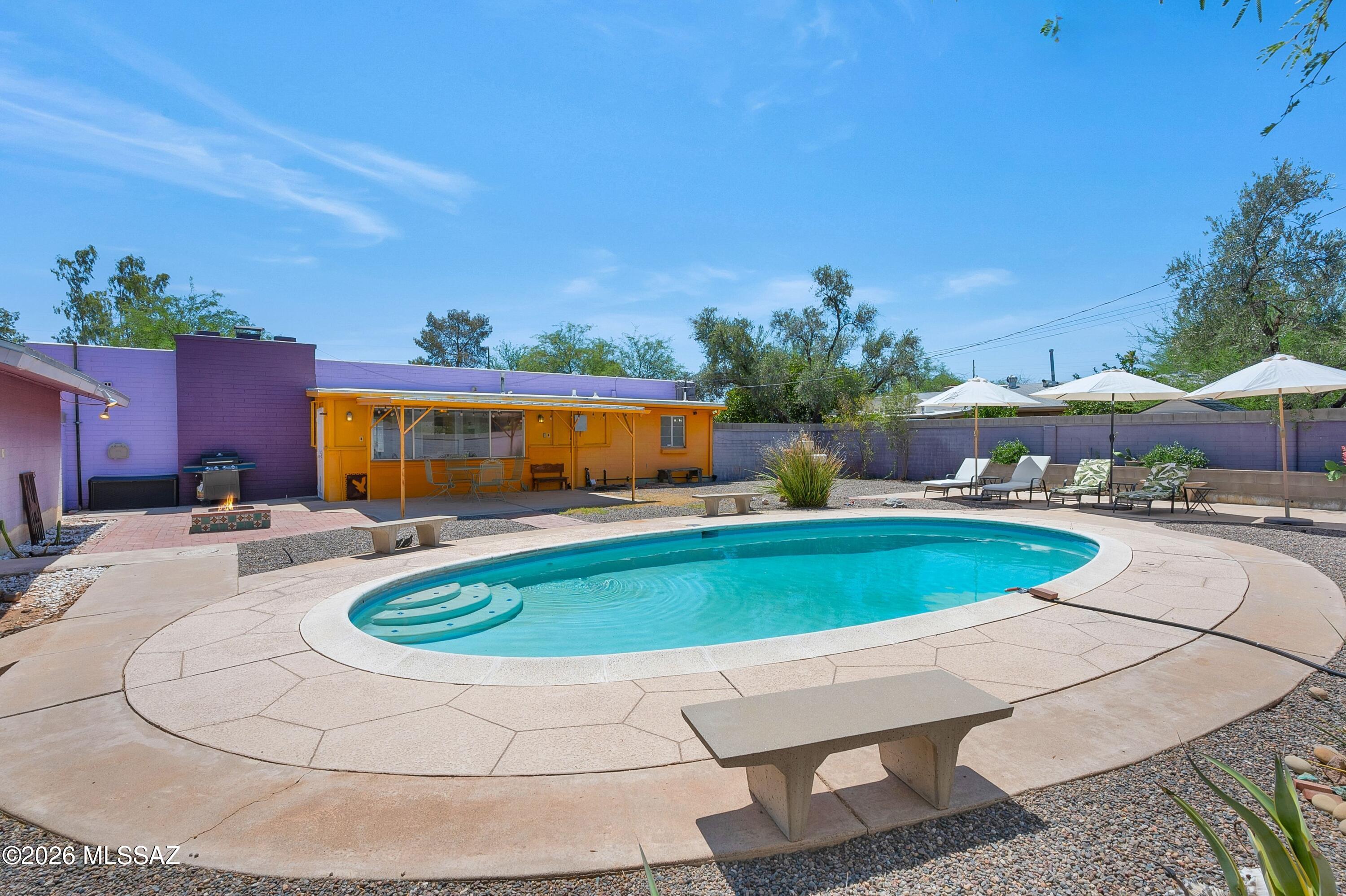 Lovingly maintained and filled with timeless character, this charming 3-bedroom, 2-bath home with a heated pool offers year-round enjoyment. Located in a desirable central Tucson neighborhood with a strong sense of community, the home features numerous recent upgrades, including a new pool heater and a newly replastered pool. A 6-foot block wall provides added privacy, creating the perfect setting for relaxing poolside. Enjoy peace of mind with a brand-new membrane roof. Additional improvements include a new water meter, new water line from the street to the home, new sewer cleanouts, an energy-efficient tankless water heater, and a new gas line ready for future upgrades. Low-maintenance desert landscaping creates a welcoming desert oasis, complemented by beautiful mountain (continued) backdrops at sunset. Newly repaved N. Bentley Avenue provides a smooth approach to the property, while an extended concrete driveway offers ample parking, including space for an RV, and leads to an oversized detached two-car garage already plumbed for a bathroom. Ideally situated just one block from Madera Park and minutes from the University of Arizona and Banner-University Medical Center. Bike, walk, or enjoy a beautiful morning stroll with convenient access to The Loop shared-use path. A wonderful combination of classic Tucson character, thoughtful updates, outdoor living, and a convenient central location.