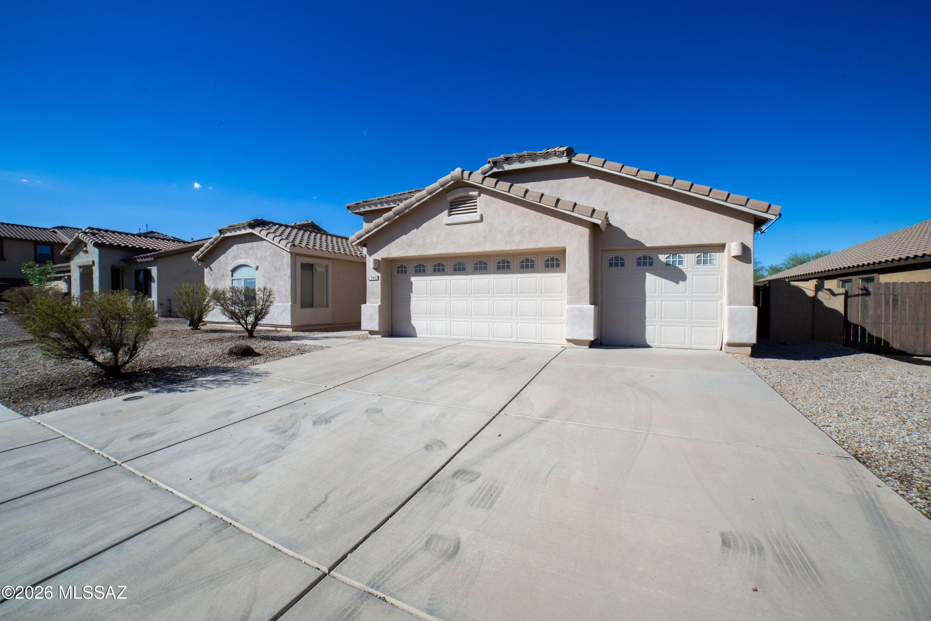 Step inside through the welcoming double-door entry and into a spacious home designed for everyday living and entertaining. The bright living room with vaulted ceilings has a fireplace, built-in niches, and backyard access. The kitchen features generous cabinetry, a center island, pantry storage, stainless steel appliances, and a dining nook overlooking the yard. Wood-look flooring flows through the bedrooms and main living areas, with ceiling fans throughout. The primary suite offers multiple windows, a walk-in closet, dual sinks, a soaking tub, and a separate shower. Outside, enjoy a large enclosed backyard with mature shade trees, garden areas, and an extended covered patio. A three-car garage adds plenty of room for vehicles, storage, or projects.
