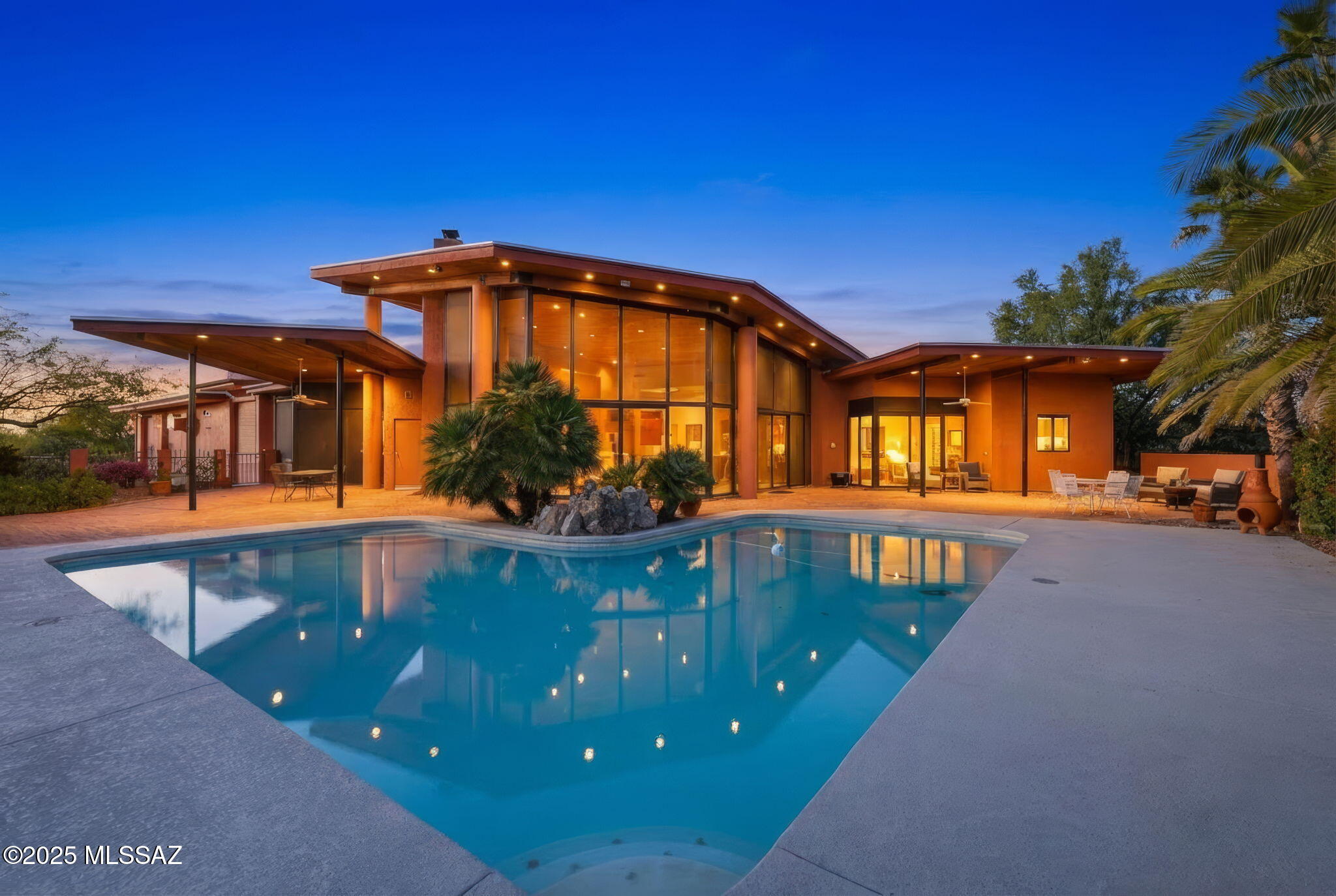 Welcome to suburban luxury at its finest on this stunning 2+ acre horse property on a corner lot that redefines desert living. This exceptional 4-bedroom, 4-bathroom home spans 3,609 square feet and showcases soaring ceilings that greet you through a dramatic foyer, creating an immediate sense of grandeur with picturesque views of a sparkling pool and several covered patios in the forefront of beautiful desert vistas.
Entertainment enthusiasts will appreciate the custom bar area, ideal for hosting gatherings that flow seamlessly between multiple  outdoor patios. The primary ensuite offers a spa-like retreat with a fireplace and direct patio access, while a guest ensuite and two additional bedrooms provide comfortable accommodations for family and guests.
See More Practical luxury continues with a 3-car garage complemented by an extraordinary 8-car shop with featuring evaporative cooling and bathroom facilities with space for the RV, off-road vehicles and any other toy that compliments the enthusiast lifestyle! 
This unique property seamlessly blends indoor comfort with outdoor recreation, offering an unparalleled lifestyle where every day feels like a retreat from the ordinary while maintaining convenient suburban accessibility.

Don't need an 8 car garage? Imagine creating a guest house or maybe using the space for a beautiful venue! Lots of possibilities for this 2000 sq. ft additional space.