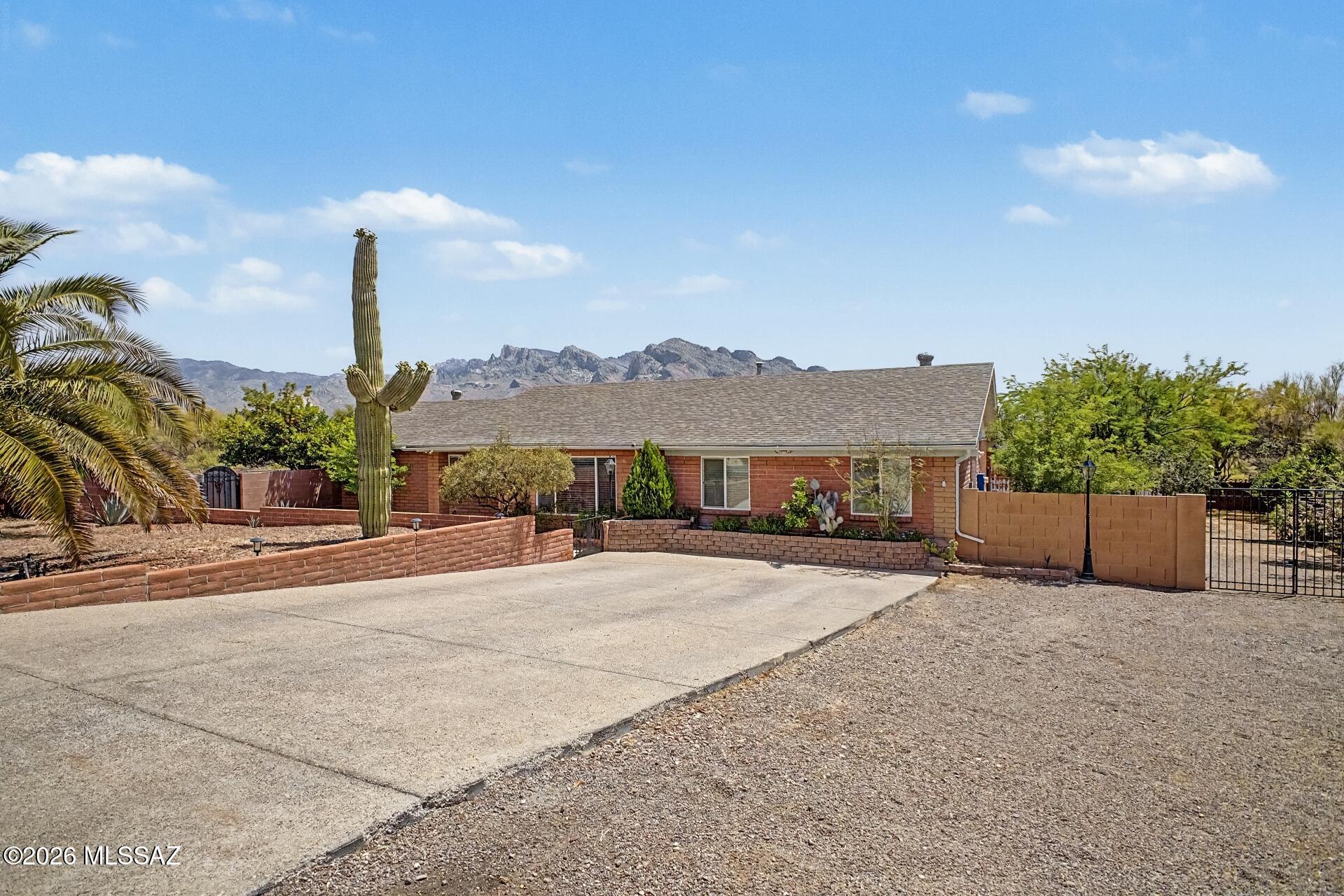 Exceptional nearly one-acre, no-HOA property in the heart of Oro Valley featuring stunning Catalina Mountain and Pusch Ridge views and a highly private setting. Situated on a premium corner lot backing to a wash, the property offers a rare sense of space with only one adjacent neighbor and a uniquely open, expansive feel. The large, block-enclosed backyard highlights incredible views and a pool with integrated waterfall and spa, multi-tiered areas, an expansive covered patio, gazebo, firepit, and built-in natural gas grill. Mature landscaping enhances privacy without obstructing the surrounding views, creating an ideal setting for both entertaining and everyday enjoyment. Inside, the home offers a 5-bedroom split floor plan with an open-concept design and extensive updates completed in 2020, including two additional bedrooms created from a permitted garage conversion. The kitchen features granite countertops and updated cabinetry, while the bathrooms include walk-in showers, updated cabinetry, and a deep soaking tub. Additional upgrades include porcelain wood plank flooring throughout, updated lighting, and modern fixtures. Improvements include a roof (2019), HVAC system (2020), water heater (2025), and induction range (2024). Ideally located near shopping, dining, and everyday amenities, this property offers a rare blend of space, privacy, views, and convenience in Oro Valley.