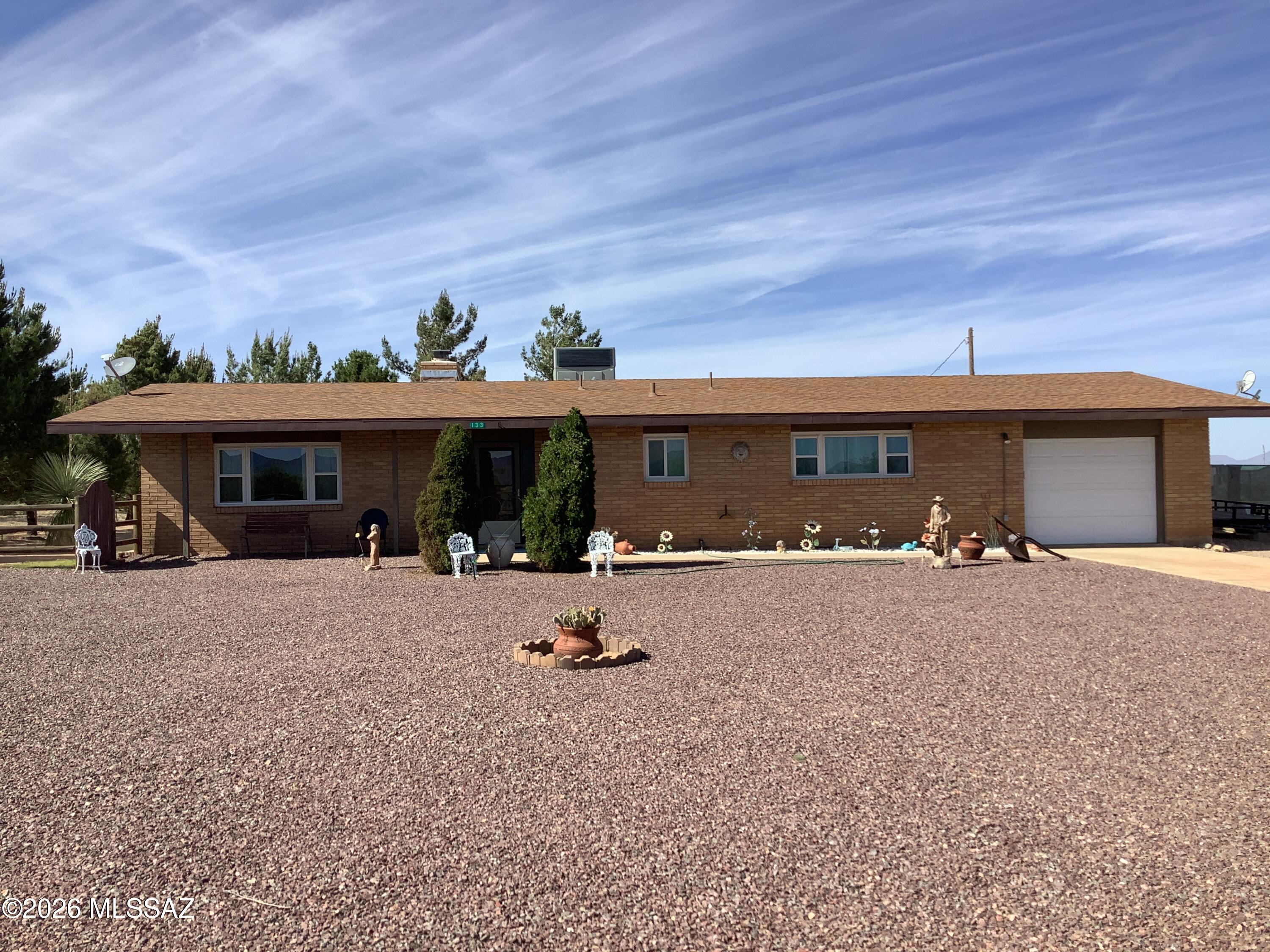 This well maintained updated 2 bedroom 2 bath home sits on 1.65 acres with additional .83 acre available on separate bill of sale.  This home had a new roof in 2021, new HVAC system in 2020, New double pane windows with warranty in 2015 and new water heater in 2018. The large living room has a wood burning fireplace and views of Cochise Stonghold. The property is manicured with decorative rock, natural grass, mature trees and fruit trees.  It is fenced and crossed fence.  The large detached garage not only has pass -through garage doors but also house large storage area with shelves. The home now has a brand new shared well in 2023 but still has capability to hook up to local water company.
