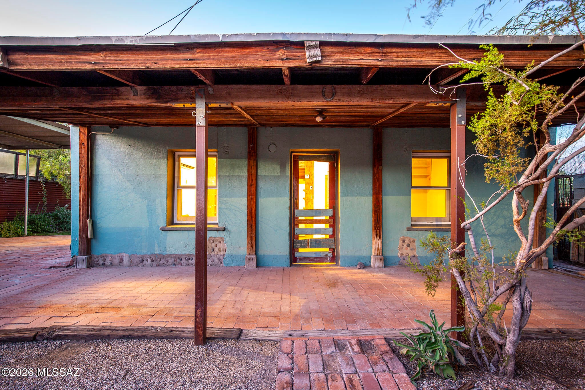 Wonderful historic adobe home with 2 bedrooms, 1 bath + bonus room off kitchen and a free standing rock masonry guest quarters with electric and mini split. Home is full of artistic details with lots of personality.  Property features a privacy wall/fencing, vehicle gate from street, large rolling gate on east fence line, outdoor shower and tub, mature landscaping, and rainwater cistern. Owned solar system, double pane windows, tankless water heater and efficient mini split heating and cooling combine for low energy cost.  I-1 zoning allows for more uses for artists, metal workers, carpenters, fabricators, and other home businesses. Next to the greenway bike path with easy access to the Loop, walking distance to 5 Points and moments from the Mercado district and Downtown amenities