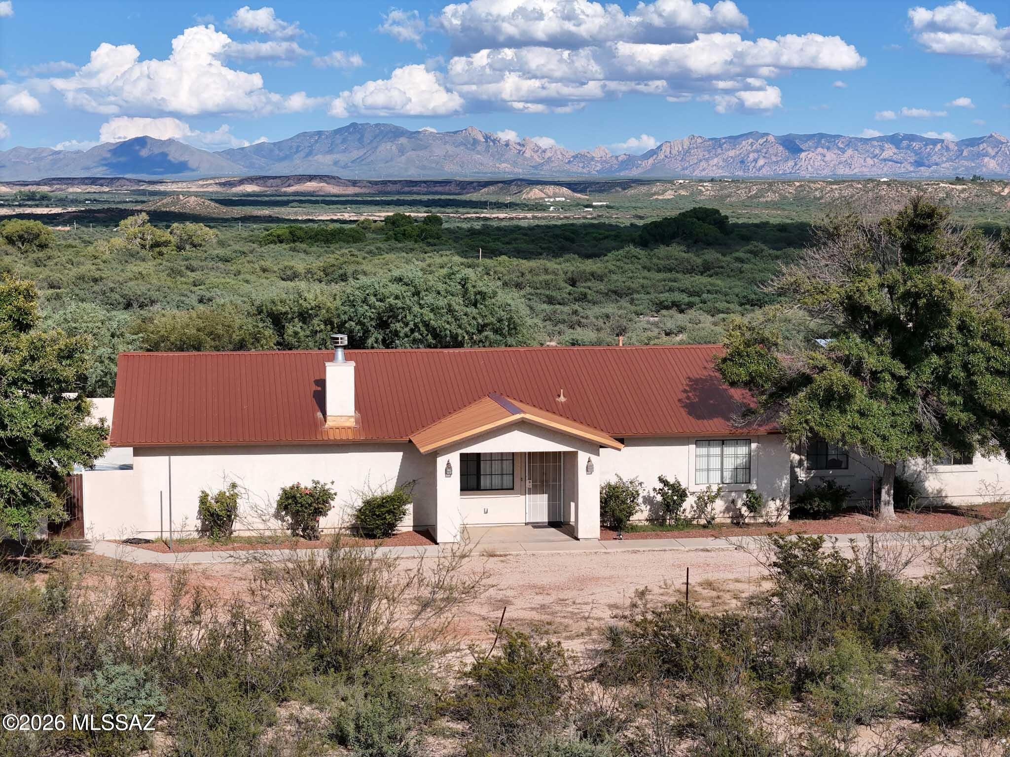 Experience desert living on four fully fenced acres with breathtaking mountain views. Watch amazing sunrises and the Dragoon Mountains glowing pink at sunset. This 2x6 construction ranch home offers 1,884 sq ft, 3 bed, 2 bath, a 2-car garage plus a separate garage/workshop. Bright, open living areas flow into a sunny kitchen. Enjoy your morning beverage on the large patio or relax in the enclosed pool and spa area. The private backyard features view fencing and a separately fenced dog run. Plenty of room for vehicles and toys with no HOA and no restrictive rules. New metal roof (2020) and new A/C.