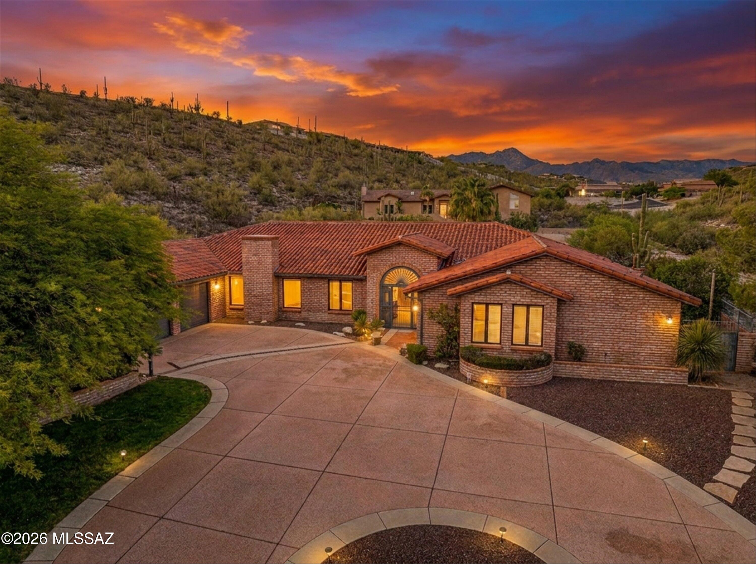 An extraordinary opportunity awaits with this stunning custom home, thoughtfully designed and built in 2000 by renowned builder Andy Arena and ideally situated on a private cul-de-sac within the prestigious gated community of Mountain Cove Estates. Expertly constructed with 2x6 framing and authentic slump block construction, this exceptional residence offers a rare blend of energy efficiency, enduring craftsmanship, and timeless Southwestern elegance.

Spanning approximately 4,674 square feet, the expansive six-bedroom, four-and-a-half-bath floorplan was thoughtfully designed to balance sophisticated entertaining with comfortable everyday living and multigenerational flexibility.

At the heart of the home, the chef's kitchen is beautifully appointed with premium Dacor and Sub-Zero stainless steel appliances, double ovens including convection, a gas cooktop with professional hood, warming drawer, prep sink, reverse osmosis system, instant hot water, abundant custom cabinetry, and an expansive island with generous seating and exceptional task lighting throughout.

Privately positioned on the east wing, the luxurious primary suite serves as a tranquil retreat with direct backyard access, an oversized walk-in closet with separate his-and-hers sections, and a beautifully remodeled spa-inspired bath featuring split vanities, elevated sinks, a soaking tub, and separate walk-in shower. Wider doorways provide enhanced accessibility and thoughtful convenience.

Designed with versatility in mind, the west wing features a private guest or in-law suite complete with a full bath, dual closets, and wider doorways. Adjacent to the suite, is a 2nd laundry room, and a spacious activity room which offers endless possibilities with pre-wiring for surround sound, a half bath, oversized closets, and sliding doors opening directly to the resort-style backyard--ideal as a game room, gym, theater, additional bedroom suite, or flexible living space.

The home also offers multiple inviting living and entertaining areas, including a formal dining room, living room and a warm family room anchored by a cozy gas fireplace. 

Generously sized secondary bedrooms provide exceptional closet space and storage throughout. Additional highlights include a flexible den, nursery, or optional fifth bedroom near the primary suite, dual laundry areas, a functional mudroom with built-in storage, recessed lighting upgrades, and premium Pella windows and doors throughout.

Step outside to a spectacular backyard retreat designed for year-round Arizona living and entertaining. The expansive covered patio features recessed lighting, ceiling fans, outdoor speakers, and a built-in gas grill, while the beautifully landscaped grounds showcase a sparkling pool, pergola with café lighting, mature fruit trees, a wood-burning fireplace, a grassy area, and raised garden beds.

Additional features include three gas HVAC units, upgraded thermostats, instant hot water and water filtration systems, central vac, central alarm system, wired speaker system, an oversized three-car garage, and extensive storage throughout.