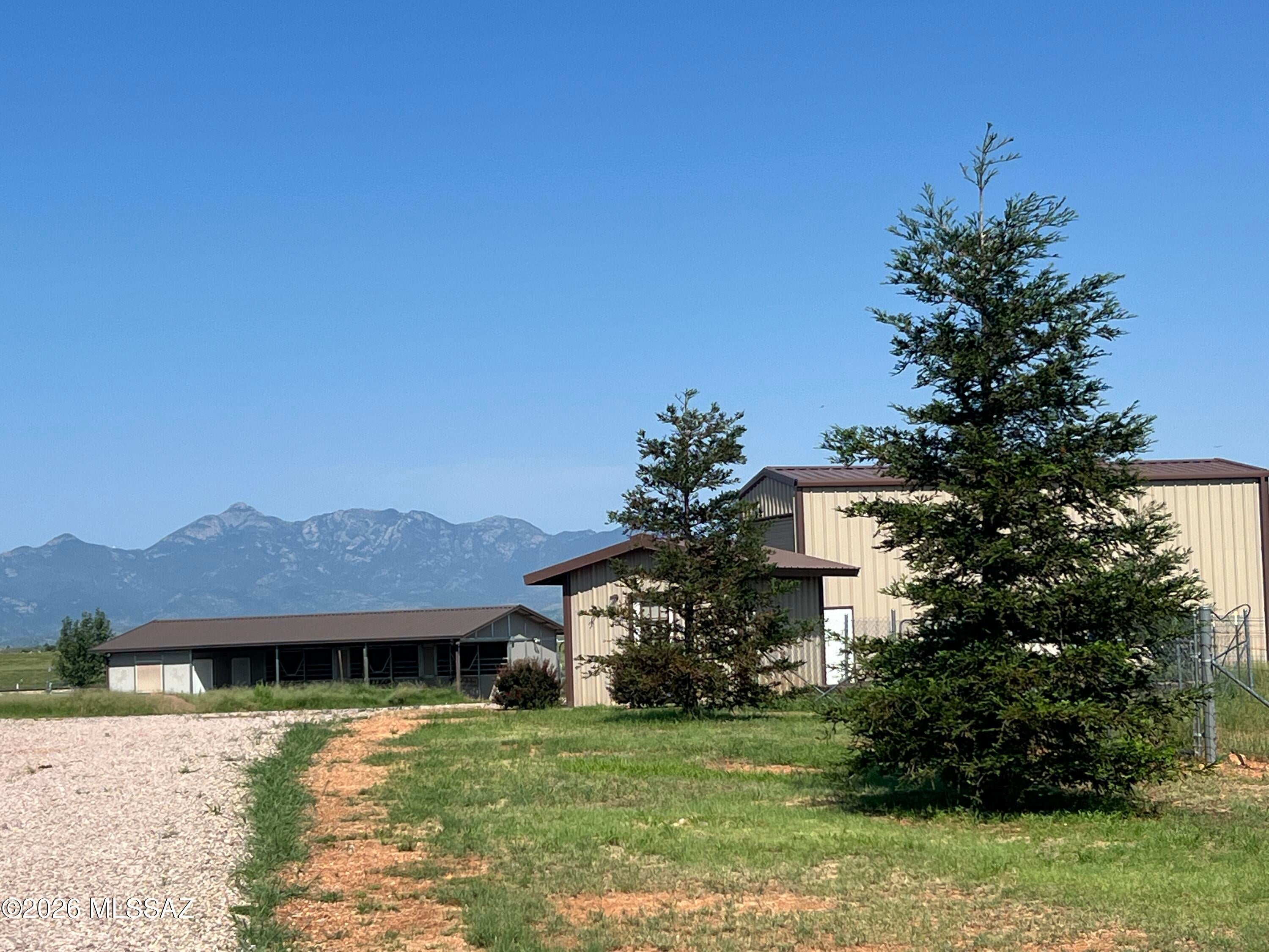 Turn Key Horse Property with owner financing below current mortgage rates available! This meticulously maintained 2339sqft 2 bedroom, 21/2 bath 2014 custom home on 9.72 acres features: Open floor plan with spacious kitchen, stainless steel appliances, granite countertops with plenty of space for baking/entertaining, alder cabinets, walk in pantry, breakfast bar, dining area with views of the Santa Rita mountains, cozy great room with pellet stove, office/den/craft room, split floor plan, provides 2 spacious master bedrooms with exterior entrances that are ensuite, walk-in closets, custom tile showers, main master has a 2  head shower and a double sink vanity, large laundry room, oversized 3 car garage (truck deep), water softener, reverse osmosis system under kitchen sink, central vac Let's go outside! Beautiful low care landscaped back and front yard, covered porches, waterfall feature, shed in yard, irrigation system, pavers, flowers, trees, block wall, decorative rock and gravel. Horse facilities include 3-stall MD metal barn with runs, separate tack and feed rooms, pavers, wash rack, perimeter fenced with cross fenced pastures for turn out and rotational grazing, riding arena with lights built with base layer and washed sand for the ultimate footing! Did I mention it has lights! 800 sqft shop building with walk through and roll up doors, 15' X 40' RV garage with 14' roll-up door, well house encloses the private well, pressure tank, filter system, back-up generator and additional work/storage space. Beautifully landscaped with flowering plants and fruit trees all on low care irrigation system. Surrounded by 360 degree views of mountain ranges, clear sky, miles and miles of riding trails, mild year round climate. Completely turn key! Move in and start enjoying! Owner financing is available.