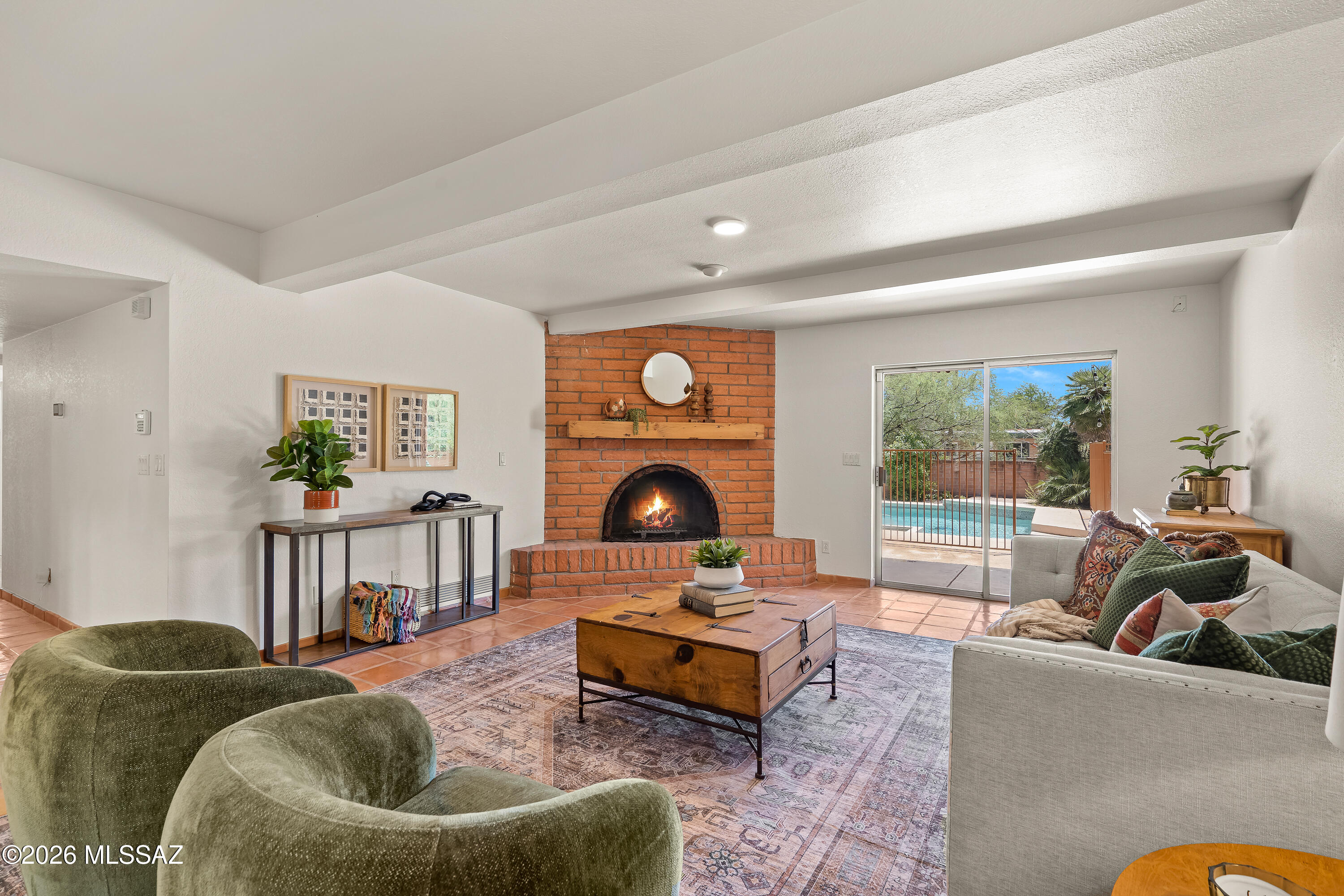 Located in Sabino Vista Hills, this masonry Territorial home blends timeless Southwestern architecture with a rich palette of natural materials and thoughtfully selected updates. Saltillo tile, arched windows, a wood-burning fireplace, and concrete overlay floors create a home that feels both authentic and inviting.
A flexible split floor plan provides separation between the primary suite and additional bedrooms, accommodating a variety of living arrangements. The kitchen is designed as the heart of the home, featuring a spacious island, quartz countertops, stainless steel appliances, and crisp black accents that carry through to the home's lighting for a cohesive finish.
The primary suite includes a generous walk-in closet, an adjoining bonus room suited for an office, library, or fitness space, and a private bathroom. On the opposite side of the home, 3 additional bedrooms are connected by a central flex space ideal for a playroom, study area, or hobby room. A second bathroom offers dual vanities and extensive storage to support everyday living.
Outdoor spaces are equally inviting, with a large covered porch overlooking the pool and mature landscaping, creating a comfortable setting for entertaining or relaxing in every season. A two-car garage and dedicated storage room provide additional functionality.
Recent improvements include a new roof (2024), water heater (2020), fresh interior and exterior paint, and a transferable termite warranty, offering peace of mind alongside enduring character in one of Tucson's most established Foothills neighborhoods (with NO HOA).