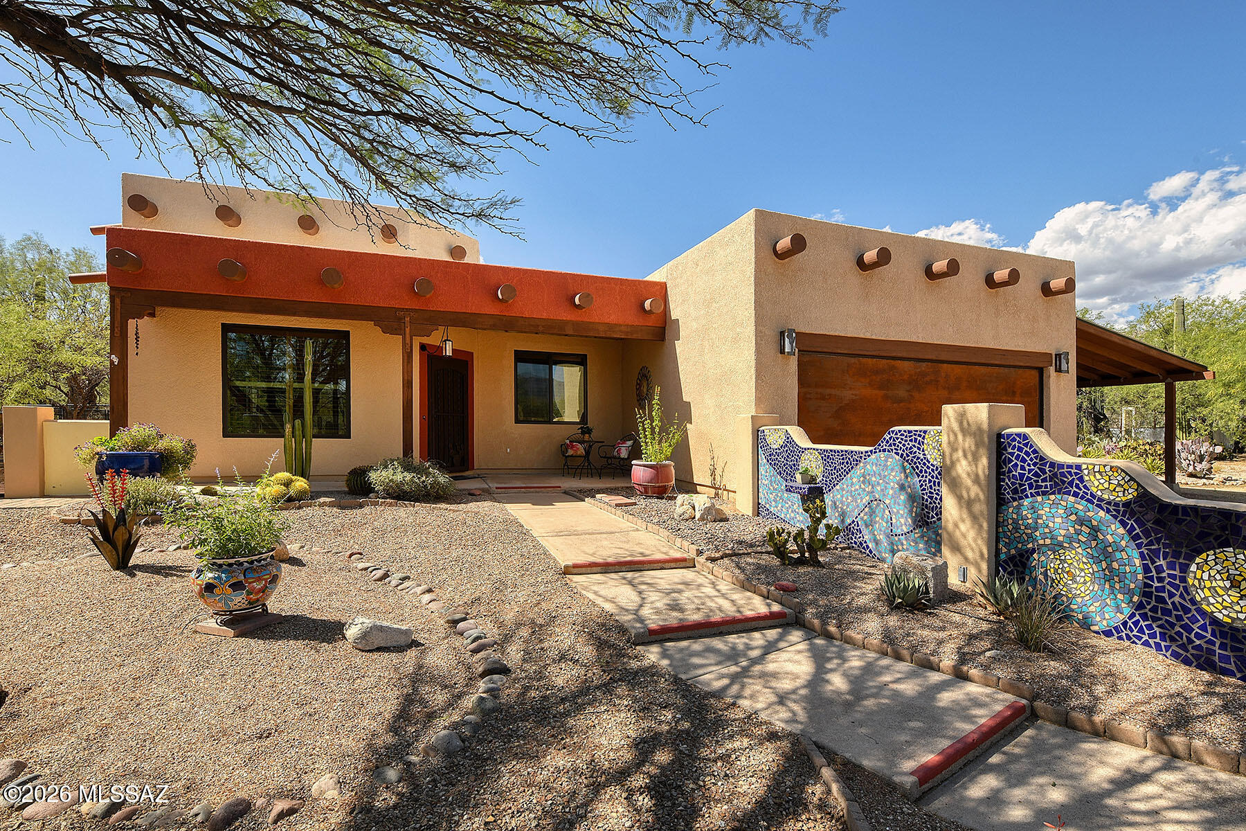 This property offers a blend of comfort and Southwest charm, set on a private 1.07 acre lot in the highly ranked
Tanque Verde School District.
Inside, the home features an open and functional layout anchored by a spacious kitchen designed for both everyday living and entertaining. A large center island provides ample prep and gathering space, complimented by a tile backsplash, stainless steel appliances and cabinetry with convenient pull-out shelves and soft-close doors. The living areas are finished with durable stained concrete floors, giving the home a clean, modern feel.  The high ceiling great room with wood-burning fireplace adds warmth and character. The primary suite is designed with comfort in mind, offering a well-appointed bathroom that includes a tiled walk-in shower and dual vanities with granite counters. Practical upgrades enhance the home's livability, including Pella windows throughout, a whole-house water softner and reverse osmosis unit for sink and fridge water/ice. Outside, the property embraces it's natural desert surroundings with a low-maintenance backyard, stunning mountain views, and two rainwater collection tanks. There's also a fenced in dog run with dog-door into the house, ideal for pet owners.
Parking and storage are abundant, with two car garage, and an additional two car carport. There is a shed/workshop for crafts or projects. Overall, this home combines thoughtful upgrades, scenic desert living, and ample space