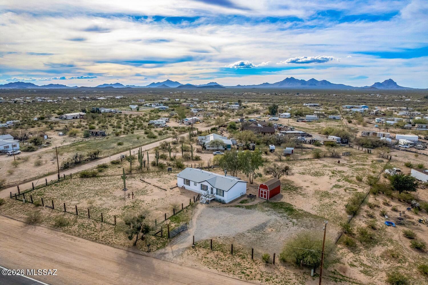 Beneath the endless canvas of wide Arizona skies, on 1.14 fully fenced and gated acres, this enchanting desert retreat invites you to slow down, breathe deeply, and live surrounded by beauty, privacy, and possibility. With no HOA and open desert views stretching in every direction, this property offers the rare freedom to enjoy the land, the silence, and the magic of the Sonoran landscape as it was meant to be experienced.

Mature saguaro cacti stand like timeless sentinels, while natural desert vegetation frames the home in authentic Southwest character. Sunrises paint the horizon in soft gold, and evenings bring glowing sunsets followed by a canopy of brilliant stars--creating a setting that feels peaceful, expansive, and deeply connected to nature. Inside, the home welcomes you with warmth and comfort. A generous 16' x 25' living room, anchored by a cozy fireplace, becomes the heart of the home--perfect for quiet evenings, intimate conversations, or relaxed gatherings after a day spent under the desert sun. Natural light fills the space, enhancing the open, airy feel.

The open kitchen is designed for both everyday living and easy entertaining, featuring a center island, abundant cabinetry, and a seamless connection to the adjoining dining area--ideal for morning coffee at sunrise or candlelit dinners as the desert cools.

A thoughtful split floor plan provides privacy and comfort. The primary suite offers a peaceful retreat of its own, complete with a walk-in closet, dual vanities, and a soaking tub--perfect for unwinding while the desert night settles in. Two additional bedrooms and a second bath provide flexibility for guests, a home office, or creative space.

Outside, the land invites endless possibilities--gardens, outdoor living areas, room for toys, animals, or simply wide-open space to enjoy the quiet. A very large Tuff Shed provides exceptional storage for tools, equipment, or hobby space, adding versatility to this already functional property.

This is more than a home--it's a private desert sanctuary where space, freedom, and natural beauty come together. A place where life moves a little slower, the skies feel a little bigger, and every day ends with the quiet romance of the Southwest.