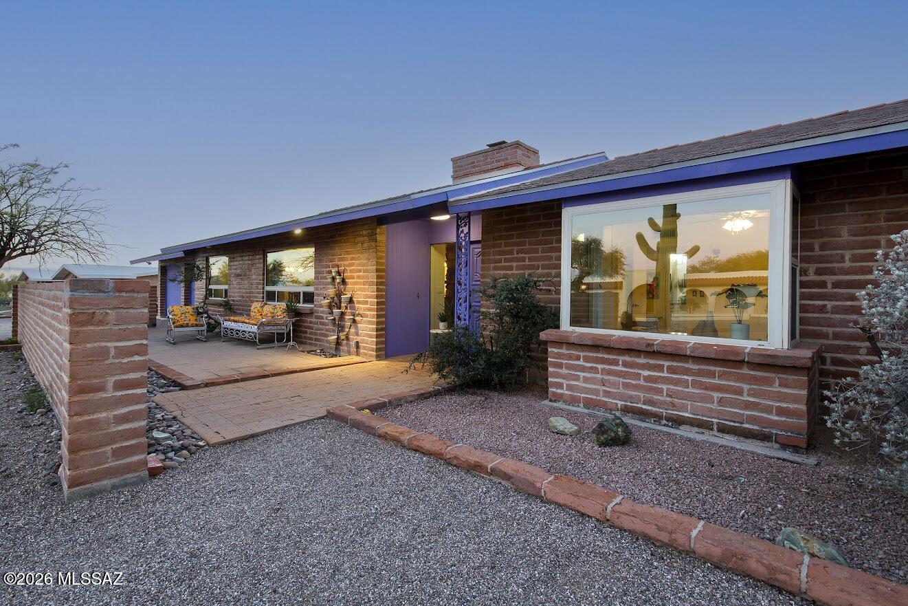 Gorgeous spacious adobe brick home on nearly an acre with sparkling pool, and a huge walled backyard overlooking the Tucson mountains to the west. Sunsets will be yours every night!   Kitchen remodel is stunning featuring a huge custom wood island, custom  soft-close cabinetry. Stainless appliances, built-in wine fridge... a kitchen designed for entertaining! Wood-burning double sided fireplace makes a cozy focal point for both living room areas. Interior of home is freshly painted. Bathrooms are both remodeled; this home is beautifully maintained & move-in ready. Two car garage has storage room, laundry room opens to backyard and garage. Place for an RV. The two back porches span the entire home, and the property extends beyond the back wall with natural desert.  Completely reroofed!