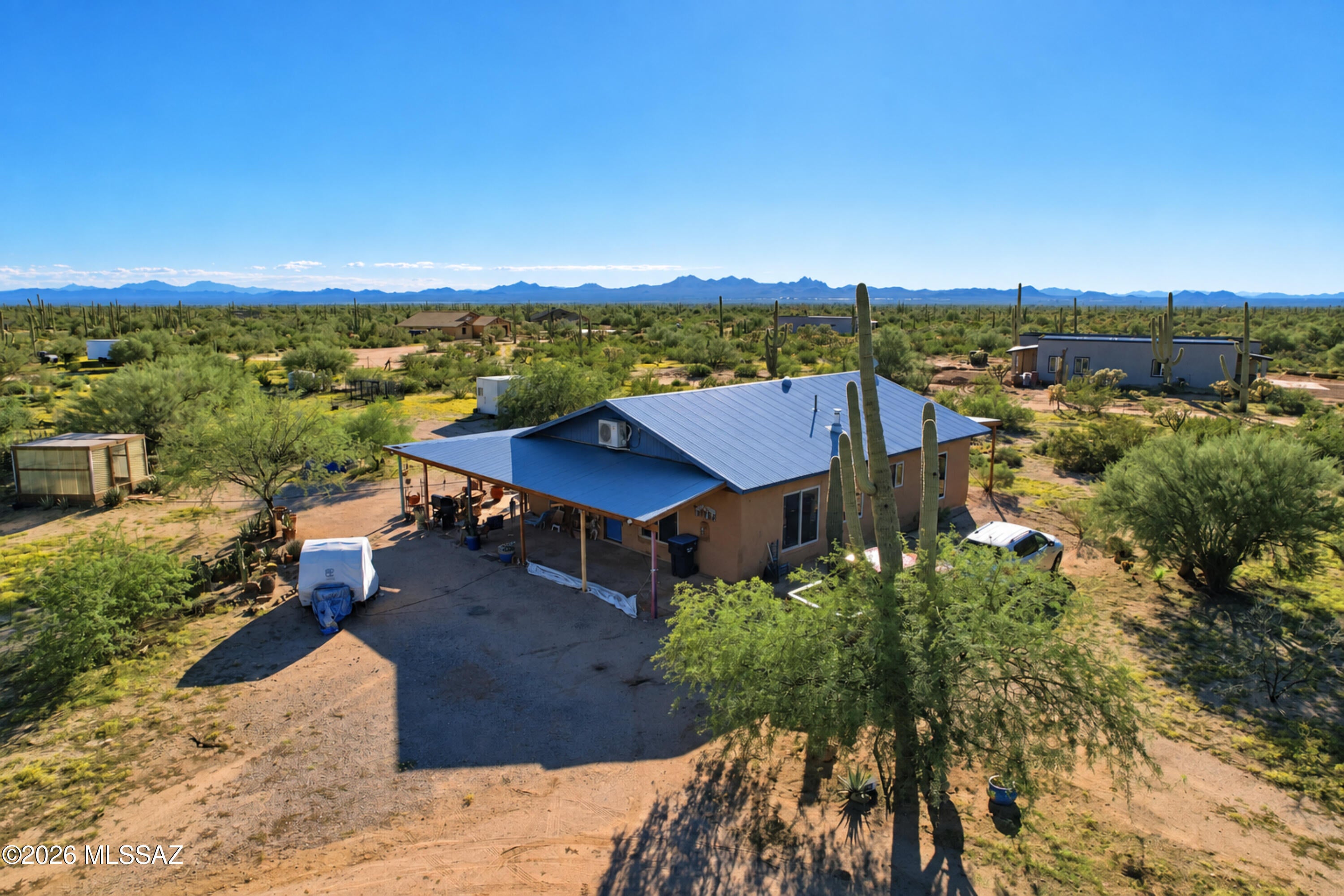 CHARMING STRAW BALE built home with METAL CORRUGATED ROOF on 2.5 ACRES!!! SOARING CEILINGS and LOTS of SPANISH and MEXICAN decor influences!!! Being sold AS IS and FULLY FURNISHED!!! OPEN CONCEPT great room and kitchen FLOOR PLAN. STAINED and sealed CONCRETE floors. MEXICAN TILE counters in kitchen. TIN  COPPER kitchen BACK SPLASH. CUSTOM wood KITCHEN ISLAND. STAINLESS STEEL electric appliances. CUSTOM wood VANITY in BATHROOM with COPPER sink. LARGE TILED walk in SHOWER. SPACIOUS great room area with a COZY WOOD BURNING STOVE for those chilly desert nights.  A 30,000 BTU mini split for heating and cooling as well as a SWAMP COOLER. LARGE laundry room with WASHER and DRYER, UTILITY SINK and TONS OF SHELVING for STORAGE. TWO separate COVERED patio areas. Property also includes a GREEN HOUSE, CONEX box SHED, and a FULL RV HOOK UP. This home has a PRIVATE SHARED well and is on SEPTIC. LOT PERIMETER is fully fenced with WIRE FENCING and a LOCKABLE gate at ENTRANCE TO home. GORGEOUS desert landscape!!! MANY SAGUAROS!!! BREATH TAKING sunrises and sunsets!!! NO HOA!!! IF COUNTRY LIVING and PRIVACY is your DREAM, LOOK NO FURTHER!!! THIS is HOME!!!