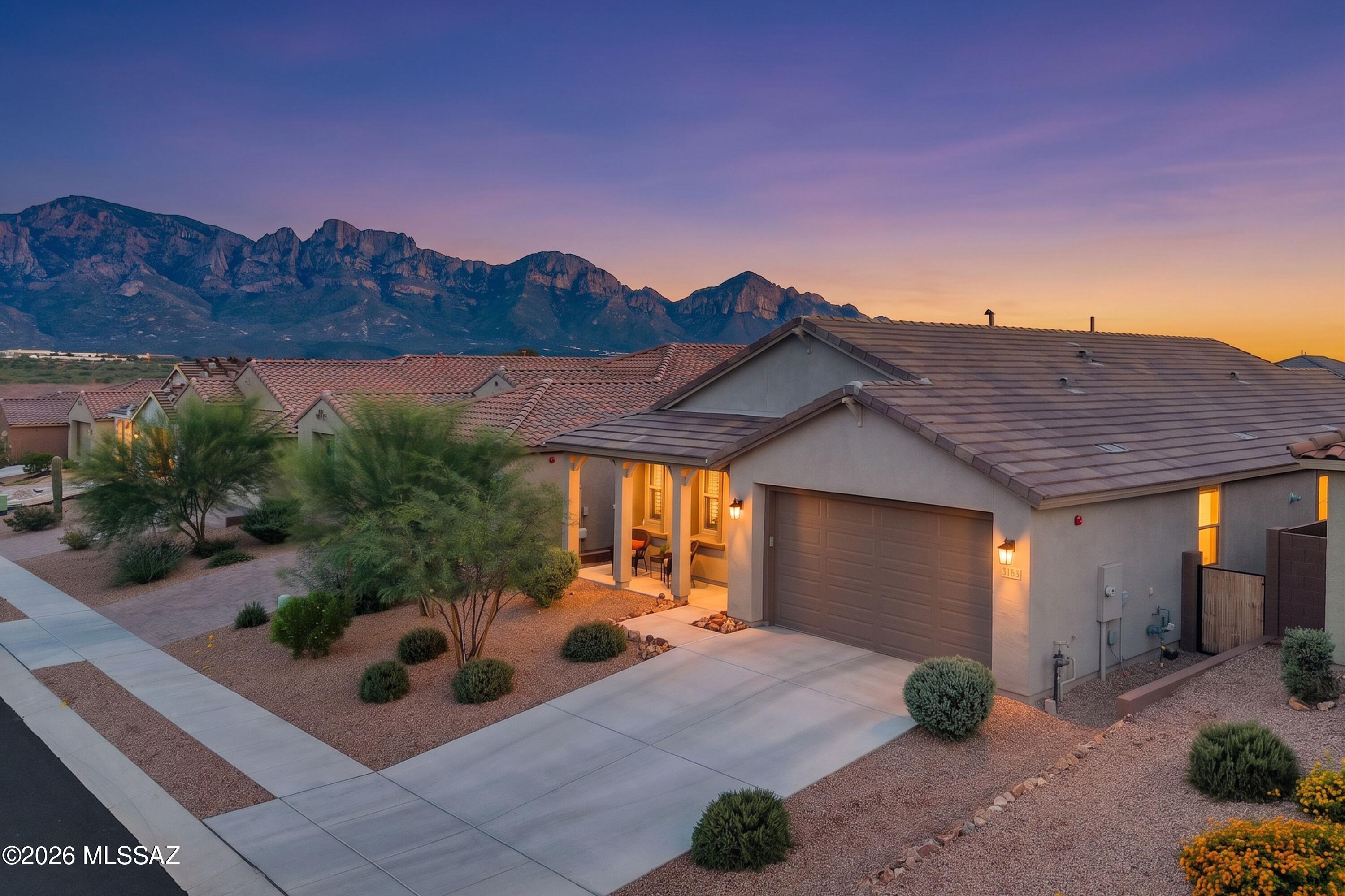 Welcome to Sunsets at Sanidine! Better than new, this beautifully appointed 2025 Pulte home where thoughtful design, timeless finishes, and meticulous care come together in effortless style. Featuring the Barletta Elevation B package, this 1,993-square-foot residence offers 3 bedrooms, 2 full baths, and a versatile den framed by elegant French doors--perfect for a home office, playroom, or additional living space.

Designed with both everyday living and entertaining in mind, the desirable split-bedroom floor plan places the secondary bedrooms and private primary suite on opposite ends of the home. At the heart of the residence is the true showstopper: a Luxe Chef's Kitchen featuring Level 5 quartz countertops, Level 4 maple cabinetry with upgraded 42-inch upper cabinets, and a high-end Whirlpool cooktop and oven package. Don't forget the upgraded built in Cafe perfect for a daily coffee bar, or even the hot plate buffet at holiday time. The oversized island doubles as a breakfast bar and gathering space, flowing seamlessly into the dining area and open-concept great room.

Throughout the home, 8-foot interior doors and 9-foot ceilings create an elevated sense of scale, while plantation shutters and a smart blackout shade at the sliding glass door add both beauty and function. Step outside to a meticulously maintained, low-care backyard and take in the breathtaking Sanidine sunsets from your own private retreat. Leave it be, add a gazebo to sit under and enjoy the mountain views, or add a pool, options are endless. A charming covered front patio offers another inviting spot to enjoy your morning coffee or unwind in the evening breeze.

The thoughtful upgrades continue with an extended-length two-car garage offering exceptional flexibility for storage, a workshop, home gym, or whatever best suits your lifestyle. Additional enhancements include an epoxy-coated garage floor AND backyard patio, soft water system, and radiant barrier added to the attic sheathing for improved insulation.

Better than new and meticulously maintained, The Sanidine Sunset is a home where every detail has been thoughtfully selected, beautifully executed, and designed to be enjoyed. Close to parks, schools, shopping and restaurants! Unbeatable location in the ever popular Oro Valley area.