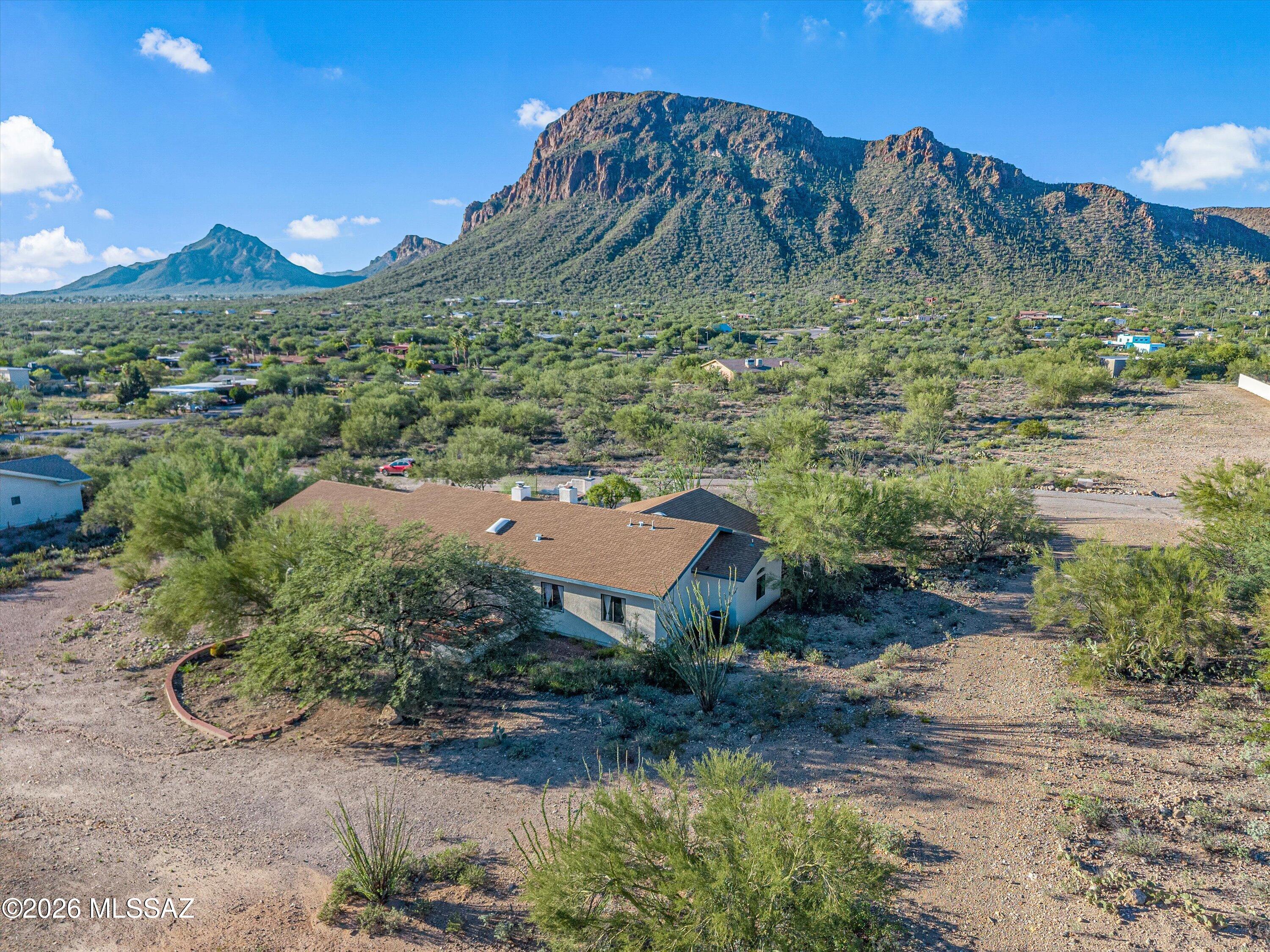 An opportunity to own this Southwest gem: 3 bed, 2 bath ranch style home complete with wood plank and wood beam ceilings, horse paddock, RV hookup, and breathtaking mountain views and sunsets on an acre lot. 20 min drive to Raytheon and 9 min to Casino Del Sol. Close proximity (end of street) to Robles Pass Trail Park providing public hiking and mountain biking trails. Garage includes a mini-split, built-in storage, overhead storage, two workshop areas, two windows, and a sink. Great for a workshop, gym, or studio to work out of. Primary bed/bath has three separate closets for your large wardrobe! Prepare your meals on eye-catching quartz counters as you enjoy the views of the mountain through the windows! Transferable termite warranty.