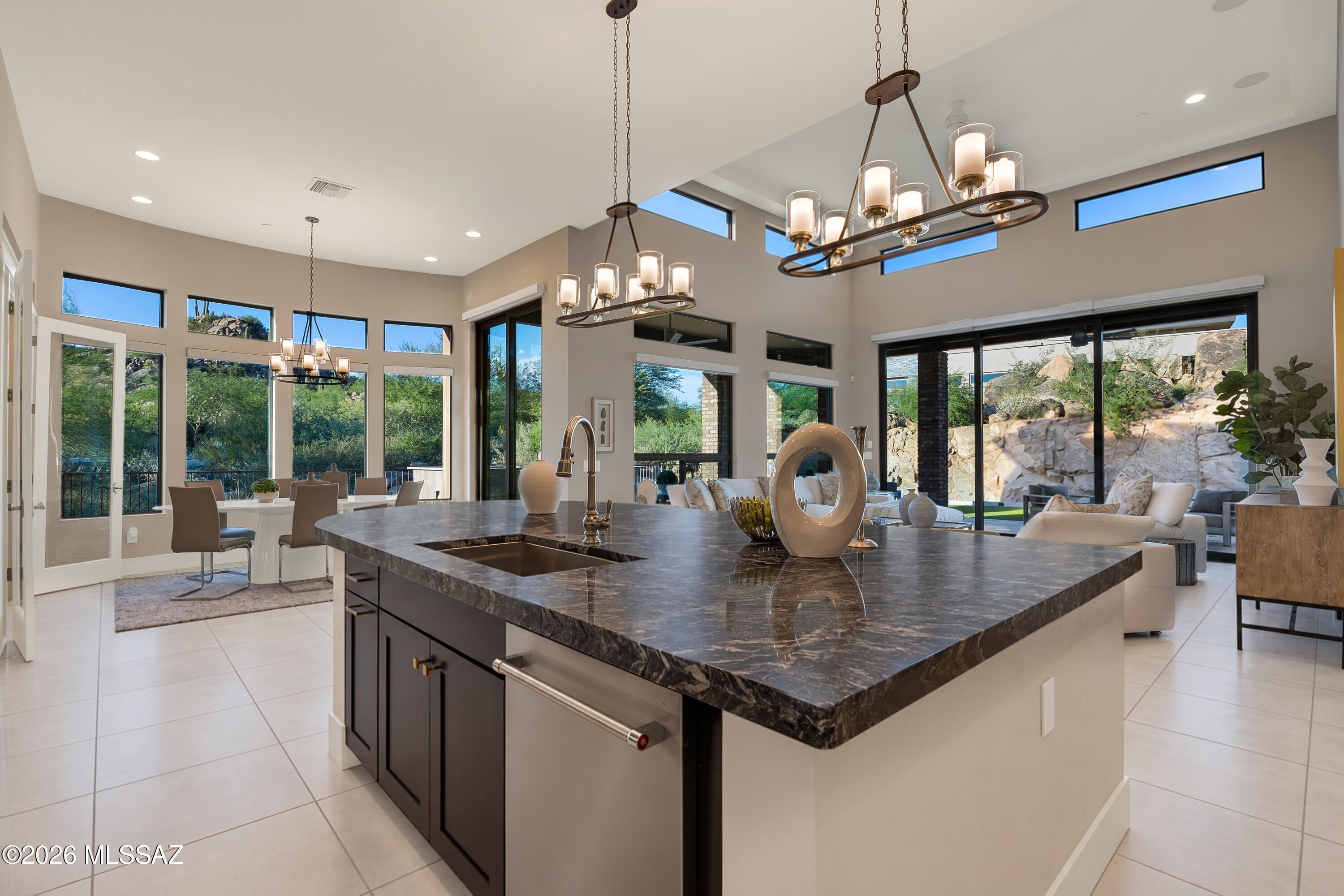 Elevated desert living in guard-gated Stone Canyon. Blending privacy with exceptional design, polished marble floors reflect natural light beneath soaring 16'+ ceilings in 2022 built home. Kitchen boasts floor-to-ceiling cabinets, granite counters & marble backsplash + wine room w/dual Sub-Zero wine fridges. Expansive retractable glass wall connects great room to private backyard w/travertine pavers, turf, outdr kitchen w/wraparound bar & gas fireplace. Primary suite includes spa bath w/slipper tub, oversize shower + custom ''California Closet''. Two guest suites w/private baths provide comfort for friends. Automated shades, oversized laundry & finished garage. Community amenities include nationally ranked golf (Stone Canyon membership required), clubhouse, dining, fitness, social + more!