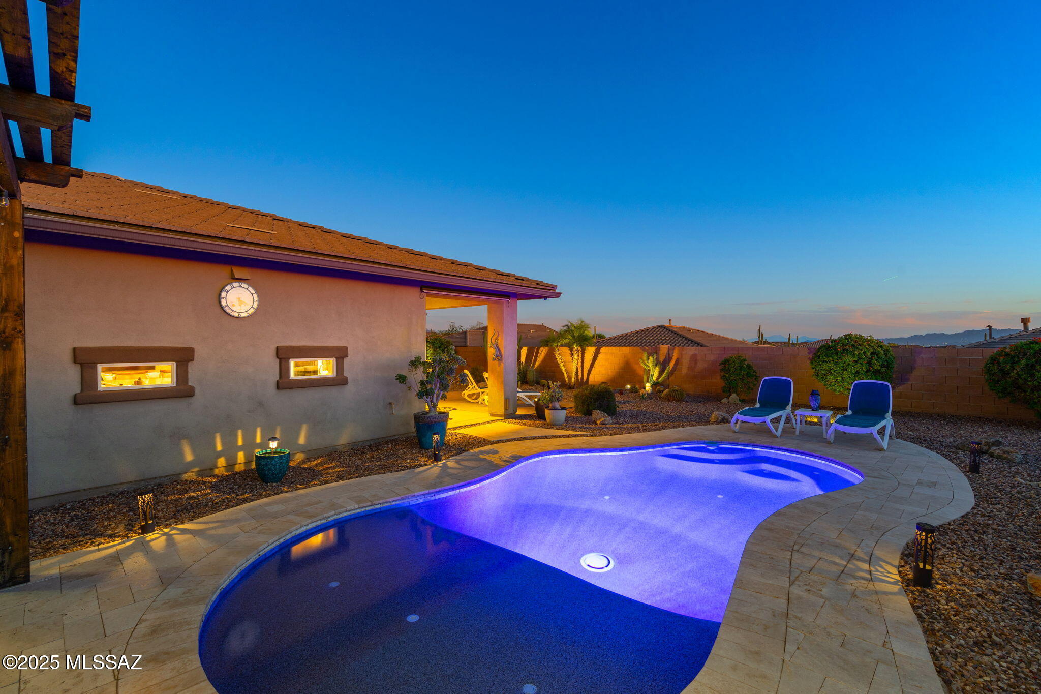 MOVE IN READY 2 bedroom, 2 bath home with a den, in gated community of Dove Mountain, down the road from the Ritz Carlton. This home sits on an oversized corner lot of 11,413 sq ft, featuring a large backyard perfect for entertaining. The backyard includes a Pebble Tec pool surrounded by travertine decking and a pergola sitting area. Sixteen-foot double glass sliders open to a patio surrounded by lush vegetation. Inside, the gourmet kitchen boasts maple cabinets with crown molding, granite counters, a tile backsplash, an electric cooktop with a vent hood, high-end stainless steel appliances, and a center island with a breakfast bar. Tile flooring and wood laminate throughout the home  Additional features include a full paver driveway, a custom wrought iron front door and side gate.