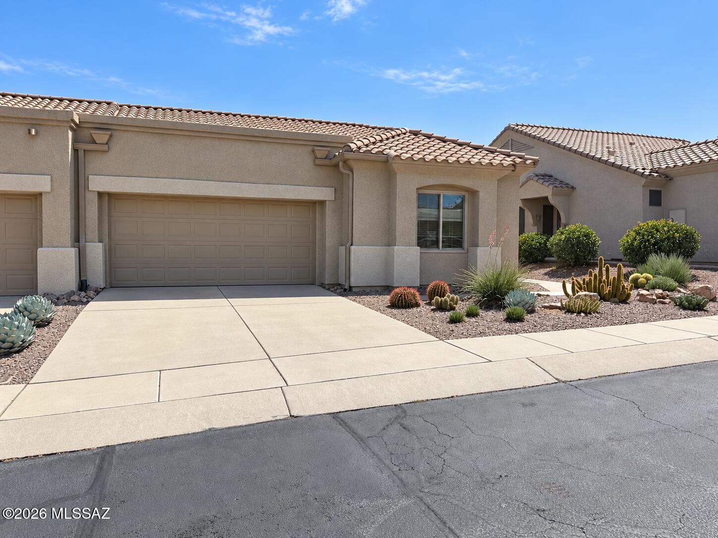 Set behind the gates of Las Campanas Village, this beautifully maintained  Buena Vista townhouse pairs a smart split-bedroom design with an impressive menu of homeowners association services.

Large neutral tile extends throughout, giving the interior a cohesive, easy-care finish. The bright great room has two ceiling fans and flows toward a breakfast nook framed by a bay window. Updated some areas in the kitchen that serves up granite countertops, stainless-steel appliances, a breakfast bar, and soft-close cabinetry--proof that practical can still look polished. 

Both bedrooms include walk-in closets and top-down, bottom-up blinds. The spacious primary suite adds a bay window and private bathroom with a double granite vanity and walk-in shower. The guest bathroom also features granit counters, soft-close cabinetry, and a walk-in shower. 

Laundry is equally well considered with a stacked full-size washer and dryer, utility sink, backsplash, tile counter, and folding space.

Enjoy mountain views from the screened Arizona room with epoxy flooring, or unwind in the landscaped backyard.

 The immaculate two-car garage offers epoxy flooring, cabinets, and a dedicated work area. A new heat-pump heating and cooling system was installed in 2024.

Homeowners association coverage includes exterior home maintenance and painting, roof repair or replacement, front-yard landscaping including rocks and plants, irrigation water and drip-system repairs, weekly trash and recycling, premium cable channels, pest control, common-area care, and a blanket insurance policy.

Tour this inviting Green Valley retreat and discover how effortless gated living can feel.