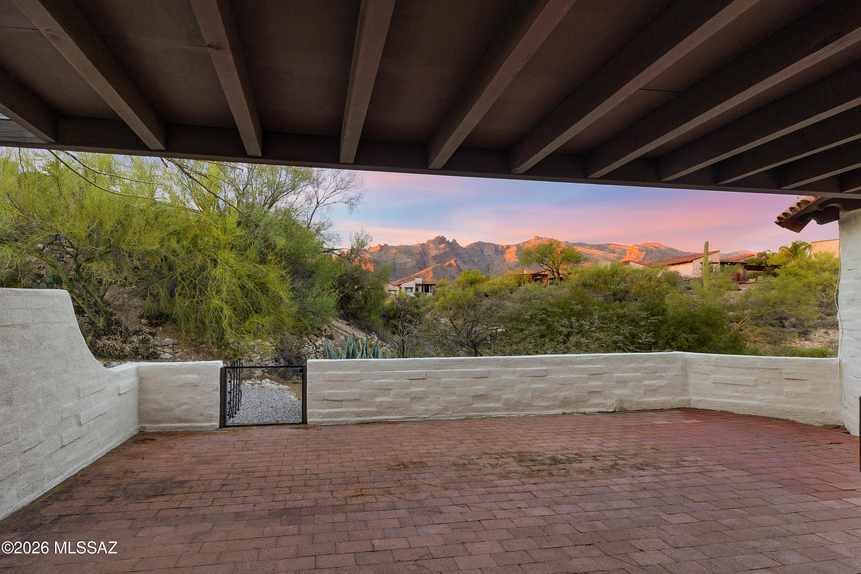 Set on one of the finest homesites within this architecturally significant enclave of historic townhomes, this rare end-unit residence captures unobstructed Catalina Mountain views from an elevated vantage point at the end of a quiet cul-de-sac. Bordering common area, the setting offers exceptional privacy--an uncommon quality in townhome living--while providing true lock-and-leave within walking distance of La Encantada Mall.
This collection of 14 townhomes is listed on the National Register of Historic Places (property taxes $1,749 2025-for the year) and was designed by renowned architect Juan Worner Baz. Trained in Mexico City and recruited by celebrated Tucson developers John and Helen Murphey, Worner Baz carried forward the Catalina Foothills aesthetic established