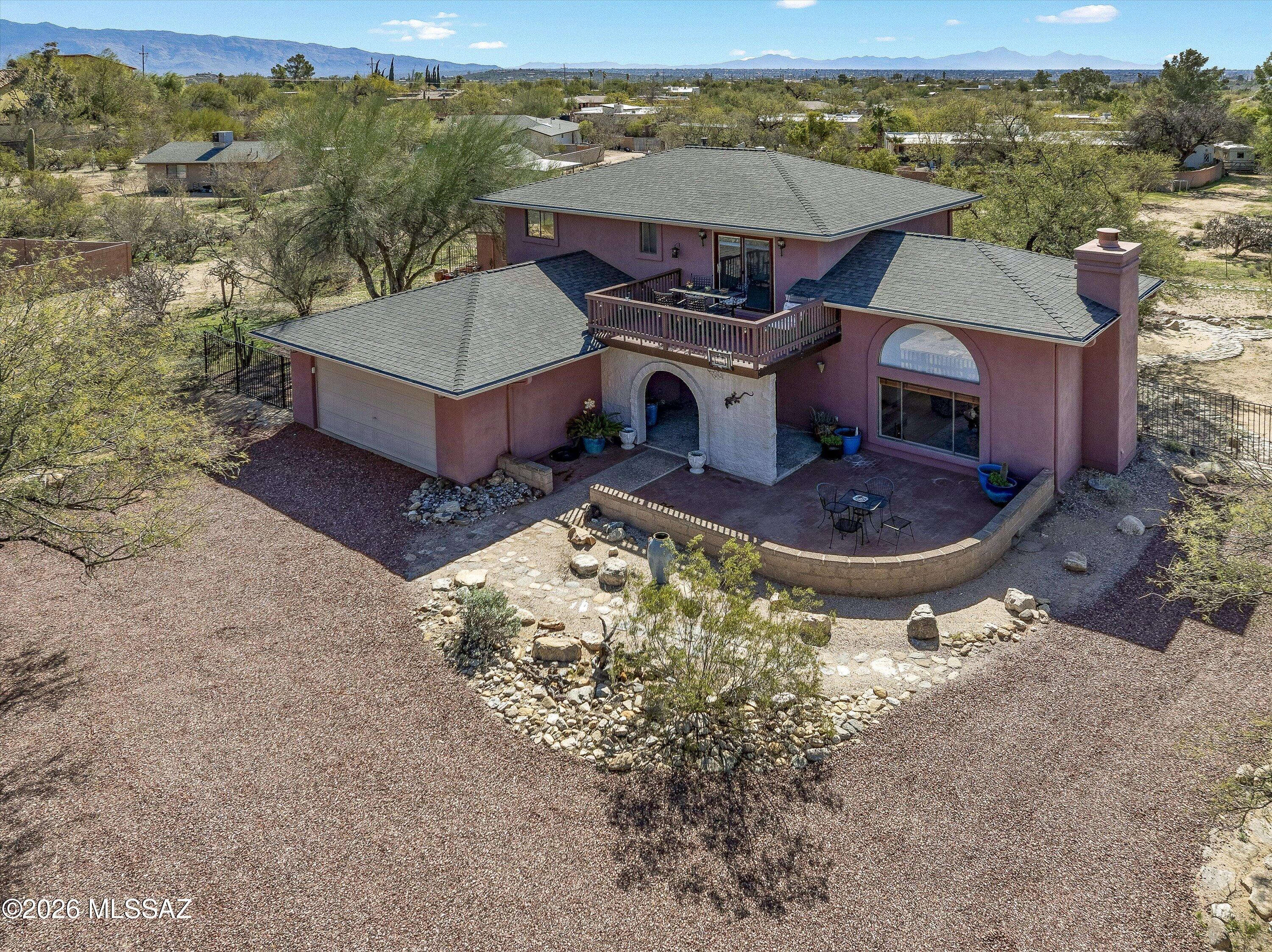 Location sets this home apart. Set at the base of the Catalina Mountains with direct access to Sabino Canyon and the Sonoran Desert, enjoy miles of world class hiking just steps away. This 2,155 sq ft 2-story home offers 4 bedrooms and 2.5 baths with privacy and sweeping mountain views. Open living & dining area features a fireplace, arched windows, and soaring ceilings. Primary suite has private balcony towards Rincons Mountains. Third bedroom/office/playroom offers its own deck with unobstructed desert and mountain views. Large 1.22 acre lot with NO HOA, fenced dog run, large shed w/cement foundation could be a workshop, & oversized garage. Quiet setting 500 feet from Bear Canyon Trailhead, just minutes to shopping and Sabino High School.