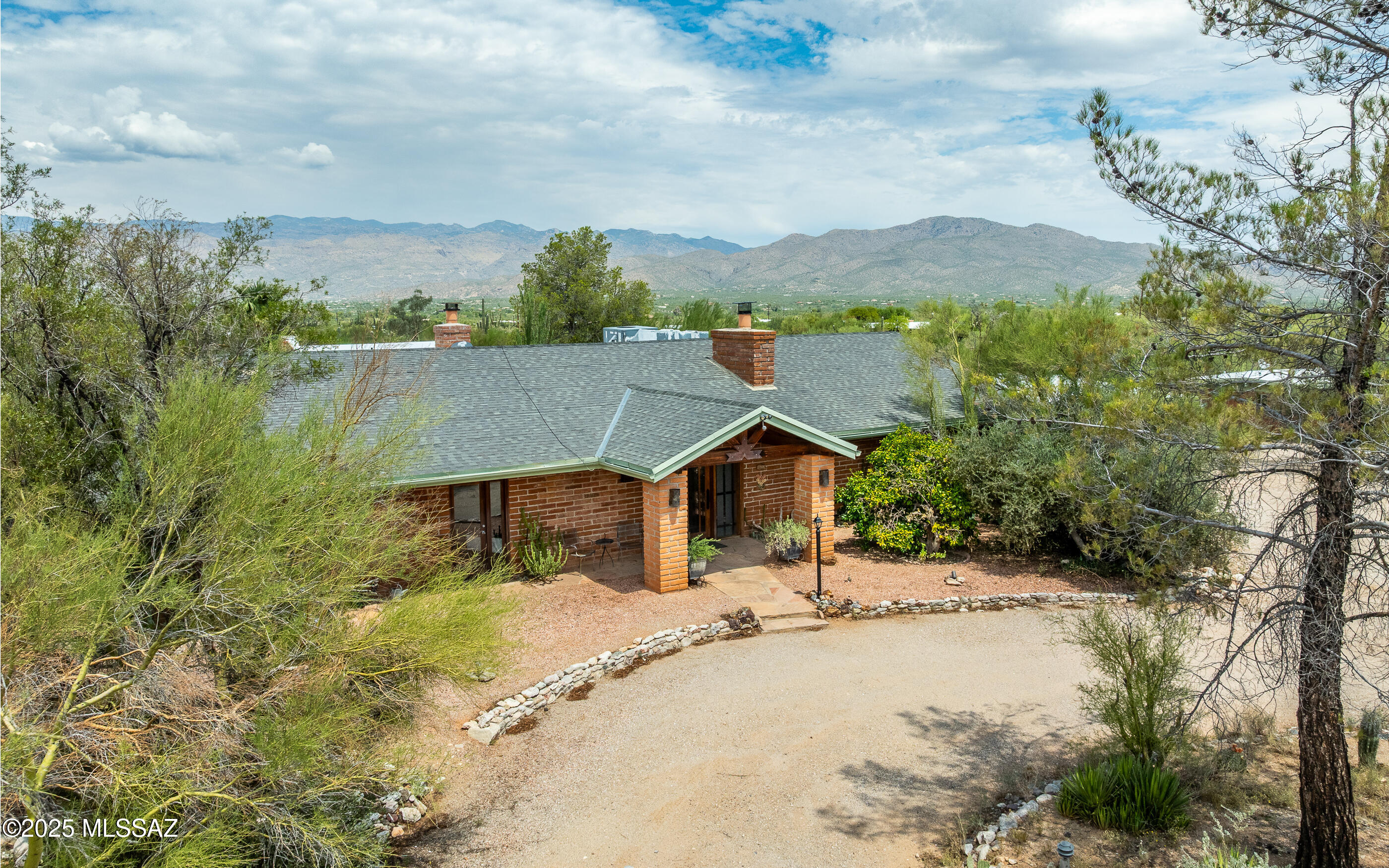 Don't miss out on this rare opportunity to own this timeless Sonoran Desert Ranch retreat, rich with history and custom craftsmanship. This one-of-a-kind home showcases knotty pine tongue-and-groove ceilings that add warmth and character throughout, blending rustic charm with modern design. Expansive windows frame sweeping views of both the Catalina and Rincon Mountains, while stunning wood beams, vaulted ceilings, and travertine tile floors create an elegant, inviting atmosphere. Set on nearly 5 acres of pristine horse property, you'll be surrounded by raw beauty desert-untouched, peaceful, and offering a sense of privacy that's hard to find. Saddle up or lace up your hiking boots Saguaro National Park is right next door. The living areas are anchored by two impressive rock fireplaces, while the spacious custom kitchen is perfectly designed for both family gatherings and culinary creativity memories. A detached guest house just steps from the main residence provides privacy and comfort with its own kitchen, electric stove, mini-split system, and full bath with shower/tub combo. Full of character, history, and natural beauty. This is more than a home it's a lifestyle!