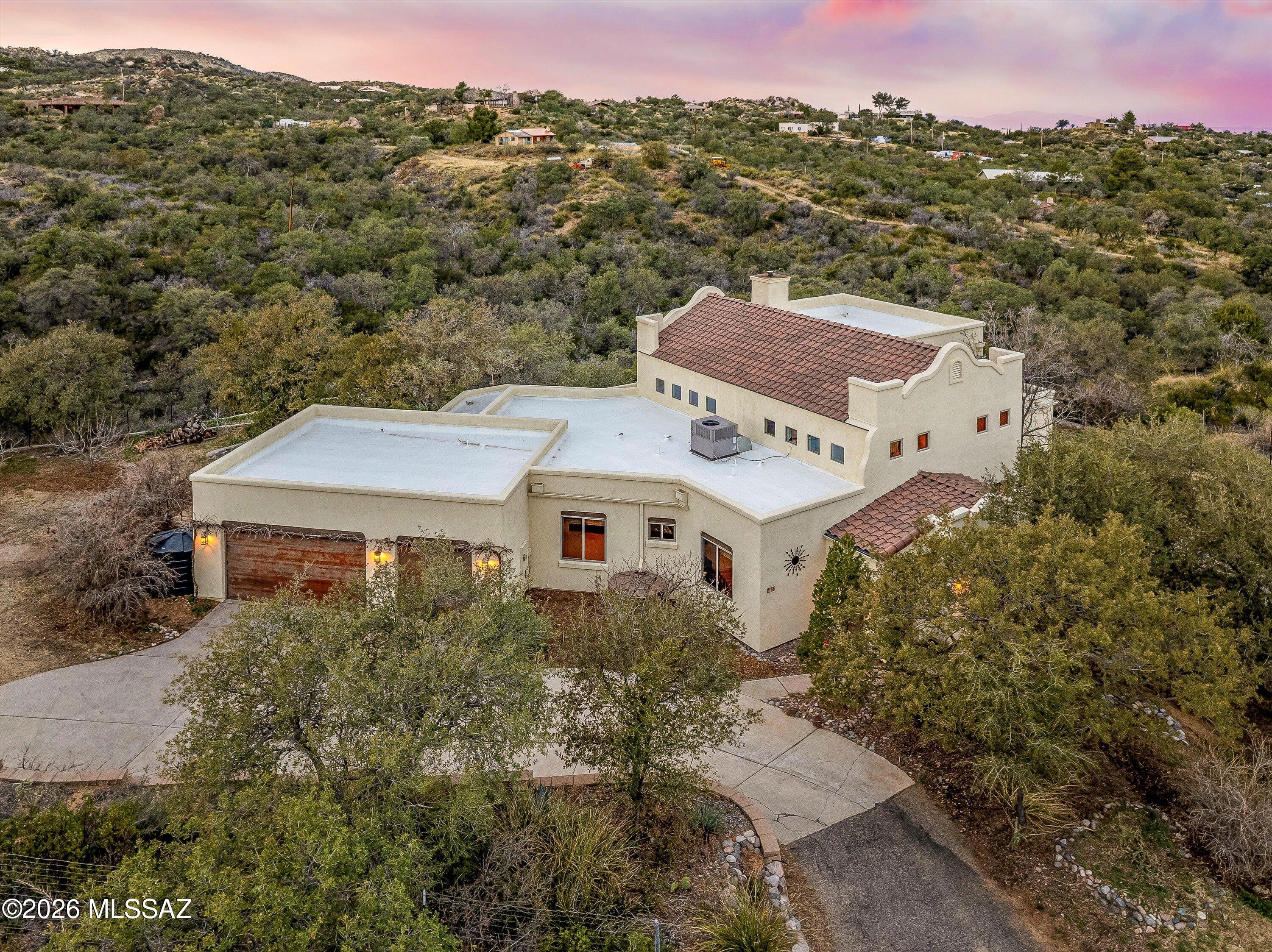 Custom hacienda nestled on a private 3.23 acres (with additional 2.82 acres available to purchase) off Cody Loop with BREATHTAKING views in the heart of Oracle! At 4,800 ft elevation, this rare offering represents true southwestern charm in a simple, yet sophisticated package. This single story home boasts soaring ceilings showcasing amazing artistic style with substantial viga beams that make an impressive statement the moment you step into the foyer. The sunken living room could easily function as an office, den, or even a formal dining area. The spacious great room highlights a cozy wood burning stove, lots of natural light and is open to the kitchen. Alder doors and cabinets throughout add an inviting warmth to the home, while the chef's kitchen offers ample storage and counterspace for all your culinary desires. The split bedroom floor plan provides privacy for all, and the primary bedroom includes a large sitting area that can function as a multitude of options. The ensuite offers a large soaking tub, separate shower and a closet you can get lost in! The stairway leads up to the big reveal: an outdoor north facing viewing deck complete with powder room and outdoor kitchen! It is truly an inspiring place to sit and stargaze, take in the amazing sunrises/sunsets or simply enjoy the nature all around you. The three car garage is a necessity, and you must explore the grounds to uncover the hidden gems, such as mature orchards with peaches, cherries, plums, figs and pears (just to name a few of the varieties grown here), custom stonework and a vast rainwater harvesting system. Only 0.5 mile from the Arizona Trail access and the surrounding Coronado National Forest, this estate offers quintessential rural living close to big city amenities. Come experience what peace really feels like!