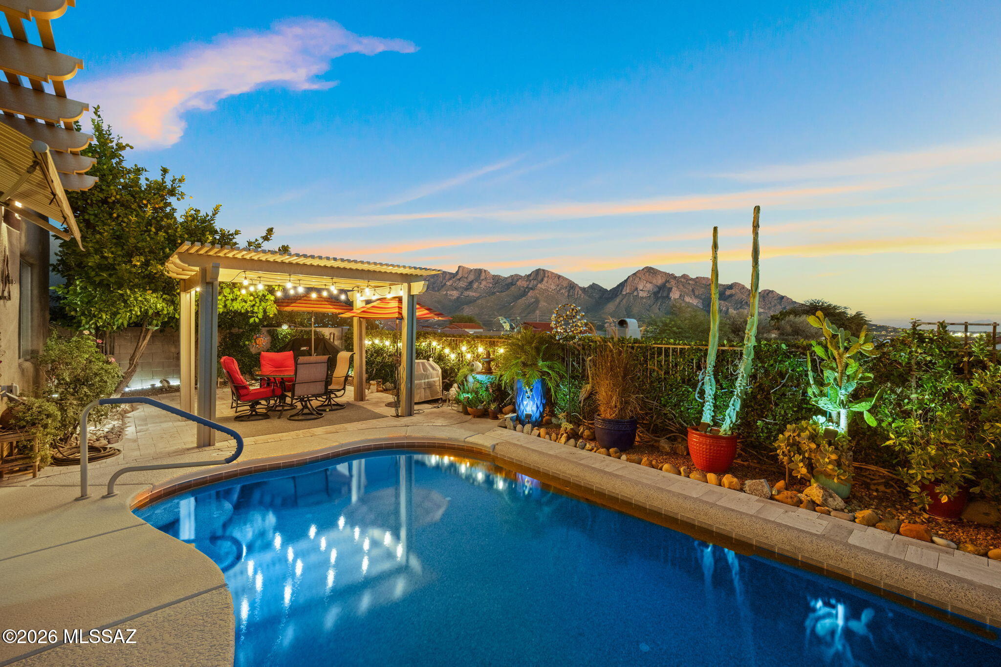 Meticulously maintained and tucked high on a large corner lot, this beautifully upgraded home blends elegant style with thoughtful designer features. Enjoy solar, energy-efficient Pella windows, EV charging, quartz countertops, custom baths, plantation shutters, stainless appliances, touch faucet, under-cabinet lighting and new ceiling fans throughout. The lush resort-style backyard showcases panoramic mountain views, sparkling heated pool, tranquil fountain, custom ramada, extended paver patio and commercial-grade misting system--ideal for year-round AZ outdoor living. Extensive landscaping includes citrus & peach trees, landscape lighting and professionally installed hardscape. Additional updates include A/C, heat pump and recent roof coating with 4-year warranty.