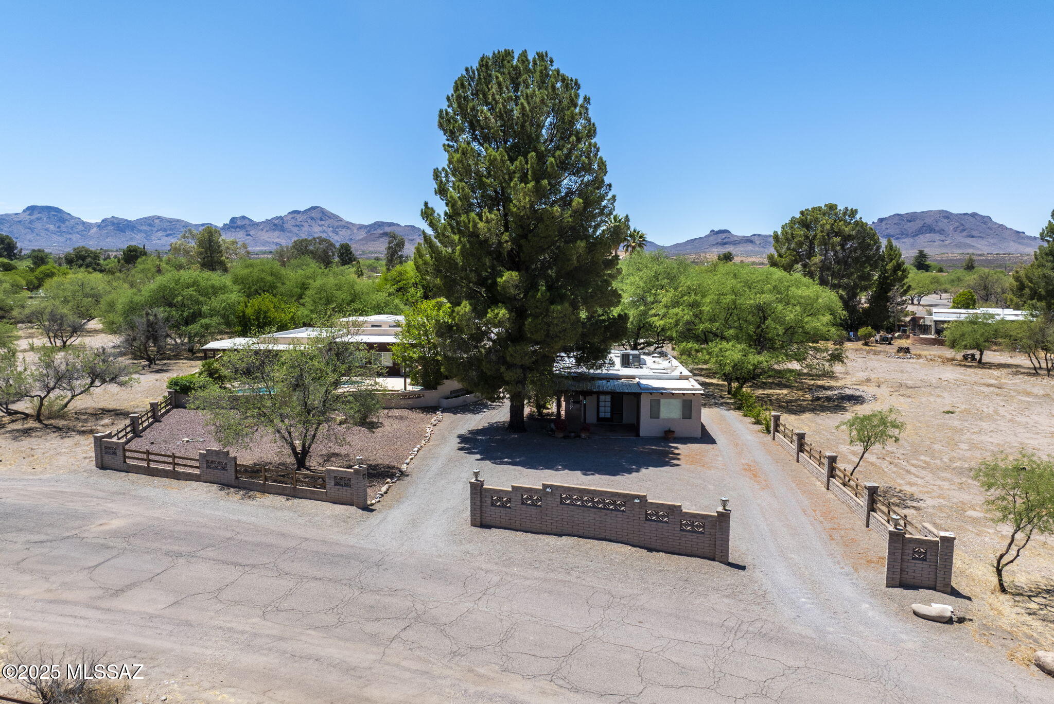 Tucked into the serene beauty of Tubac's high desert landscape with views of the Santa Rita Mountains, this private estate offers a seamless blend of refined living and relaxed Southwest charm. Nestled on nearly an acre (0.86 ac), it features private pool, basketball court and detached casita with kitchen, bedroom and full bath, perfect for multi-generational households or rental. Open-concept floorplan is designed for maximum privacy with primary suite, generous secondary bedrooms and bath, plus bed and bath featuring exterior access. Attached studio features half bath, sink and exterior access. Outdoors, you'll find planting beds, covered and open terraces for fun-filled days, elegant entertaining. Each element of this Tubac retreat has been carefully considered and thoughtfully crafted