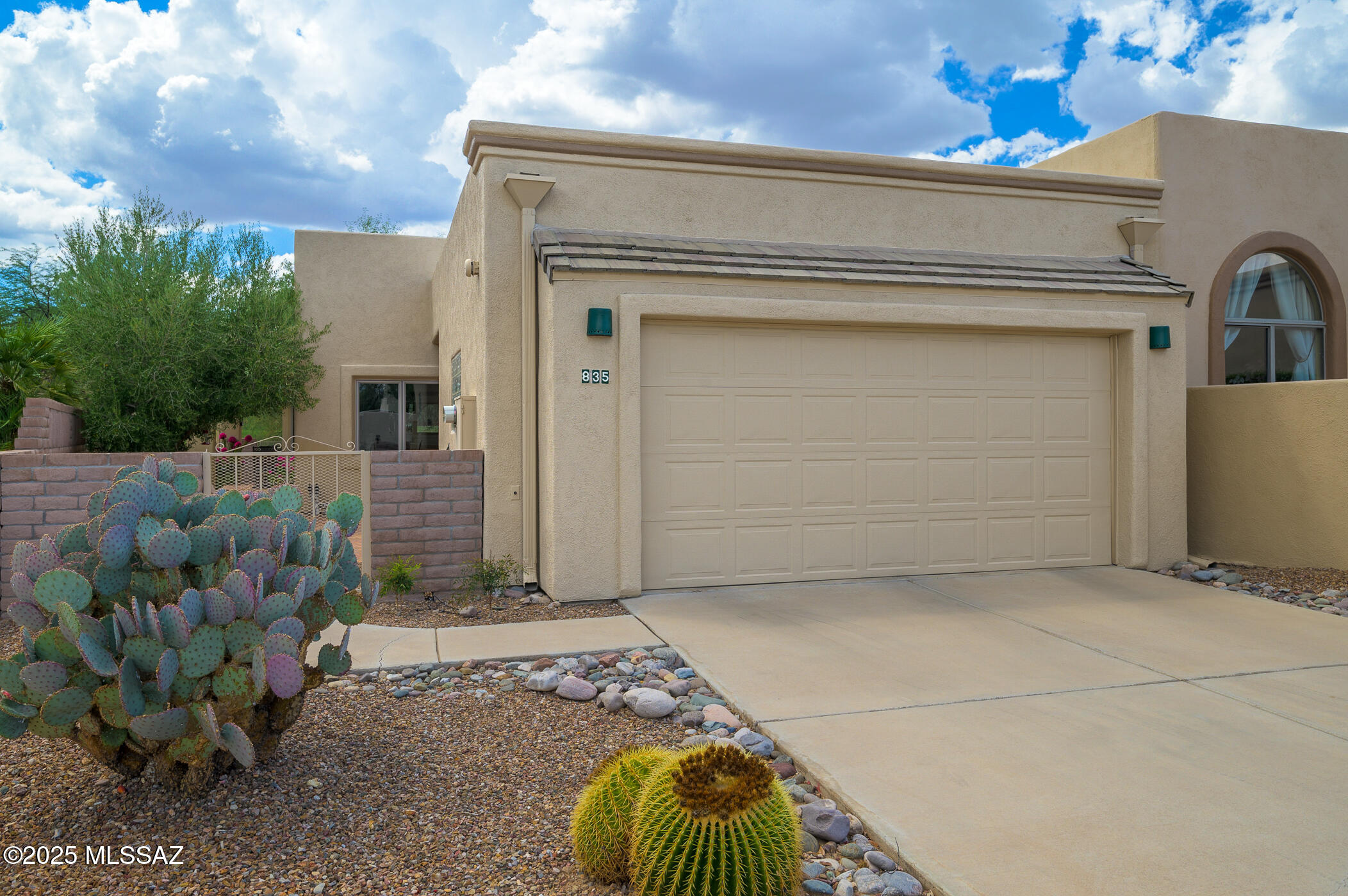 Embrace the serenity and leisure of retirement living at its finest, nestled in an excellent golf course setting designed exclusively for the active retiree. This charming 2-bedroom, 2-bathroom home offers an idyllic blend of comfort and style, beginning with an inviting Mexican tile courtyard that gracefully opens to an expansive, verdant side yard adorned with lush artificial turf—perfect for effortless outdoor enjoyment without the hassle of maintenance.  Step inside to find 10-foot ceilings, arched passageways, and brilliant white walls that amplify the natural light flowing through wood-clad Anderson windows. The heart of the home, a spacious kitchen, boasts a generous array of cabinets and a quaint eating area framed by oversized windows that showcase captivating views of the surrounding desert flora.  Elegance is in the details with solid wood doors and southwest tile floors that exude a timeless appeal. Step outside to the covered patio, where you can unwind under the majestic canopy of towering mesquite trees, creating an ideal sanctuary for peaceful afternoons filled with relaxation. This gem is tucked within a secure, gated community, complete with private pool and spa amenities, as well as access to all the exclusive offerings of Green Valley Recreation. Indulge in a lifestyle where every day feels like a getaway. This home may be cozy in size, but it's grand in its potential to create your perfect retirement oasis.