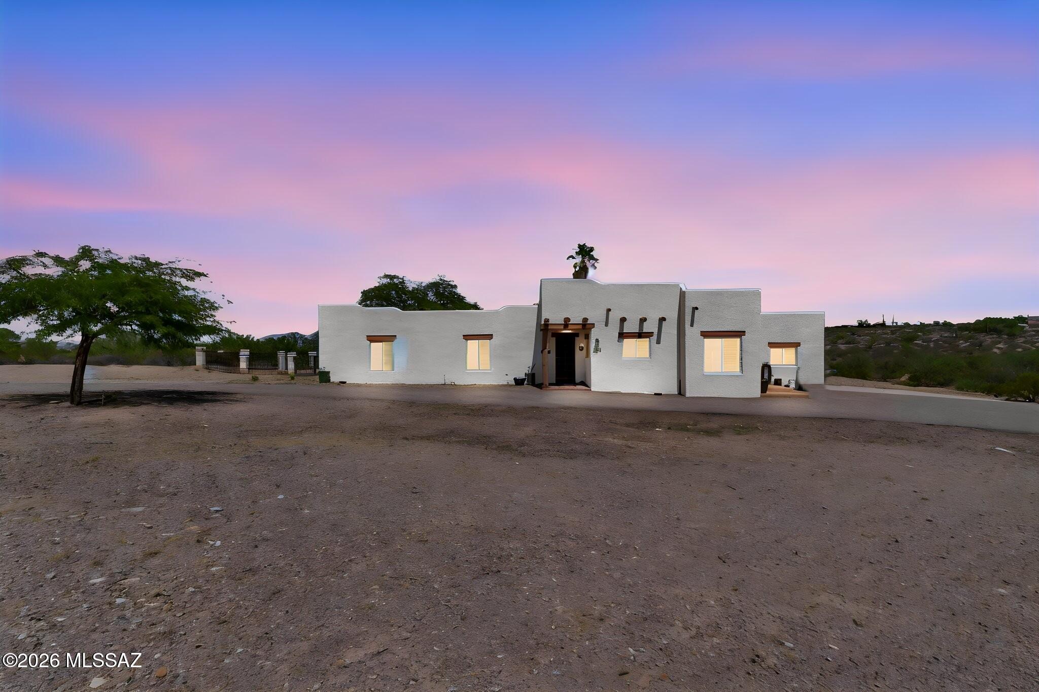 Welcome to your own slice of the Sonoran Desert! Set on 4.38 acres in the West Tucson Foothills, this charming Santa Fe-style retreat delivers space, privacy, personality, and those BIG Arizona views everyone dreams about. Step inside and immediately feel the warmth of soaring wood-beamed ceilings, beautiful Saltillo tile, abundant natural light, and a cozy wood-burning beehive fireplace that gives the great room unmistakable Southwest character. The spacious kitchen is made for gathering, with granite countertops, generous cabinetry, built-in appliances, pantry storage, and a large center island perfect for morning coffee, casual dinners, or margaritas with friends. When it's time to unwind, escape to the primary suite with direct access to the covered patio and pool, plus a jetted tub ready for a long soak at the end of the day. Then step outside--because this is where Arizona really shows off! Spend sunny afternoons floating in the sparkling pool, relax beneath the covered patio with sweeping Tucson Mountain views, and watch the desert transform as the sun goes down and the city lights begin to twinkle. Wine in hand is optional...but highly recommended. And with 4.38 acres, why stop there? Bring the horses. Create the little farm you've always wanted. Build that dream workshop or oversized garage for your cars, toys, hobbies, or weekend tinkering. There's room here to dream BIG. You'll also find a large dog pen, plus a 2-car garage with epoxy floors and an oversized storage closet. Peaceful, private, and wonderfully tucked away, yet conveniently located with easy access to I-10 and downtown Tucson. This isn't cookie-cutter Arizona living--it's character, land, views, possibilities, and a whole lot of desert magic. Come see it for yourself. You may never want to leave. Priced well below market value for any modifications needed. Check the adjacent parcels for recent sales. WOW!