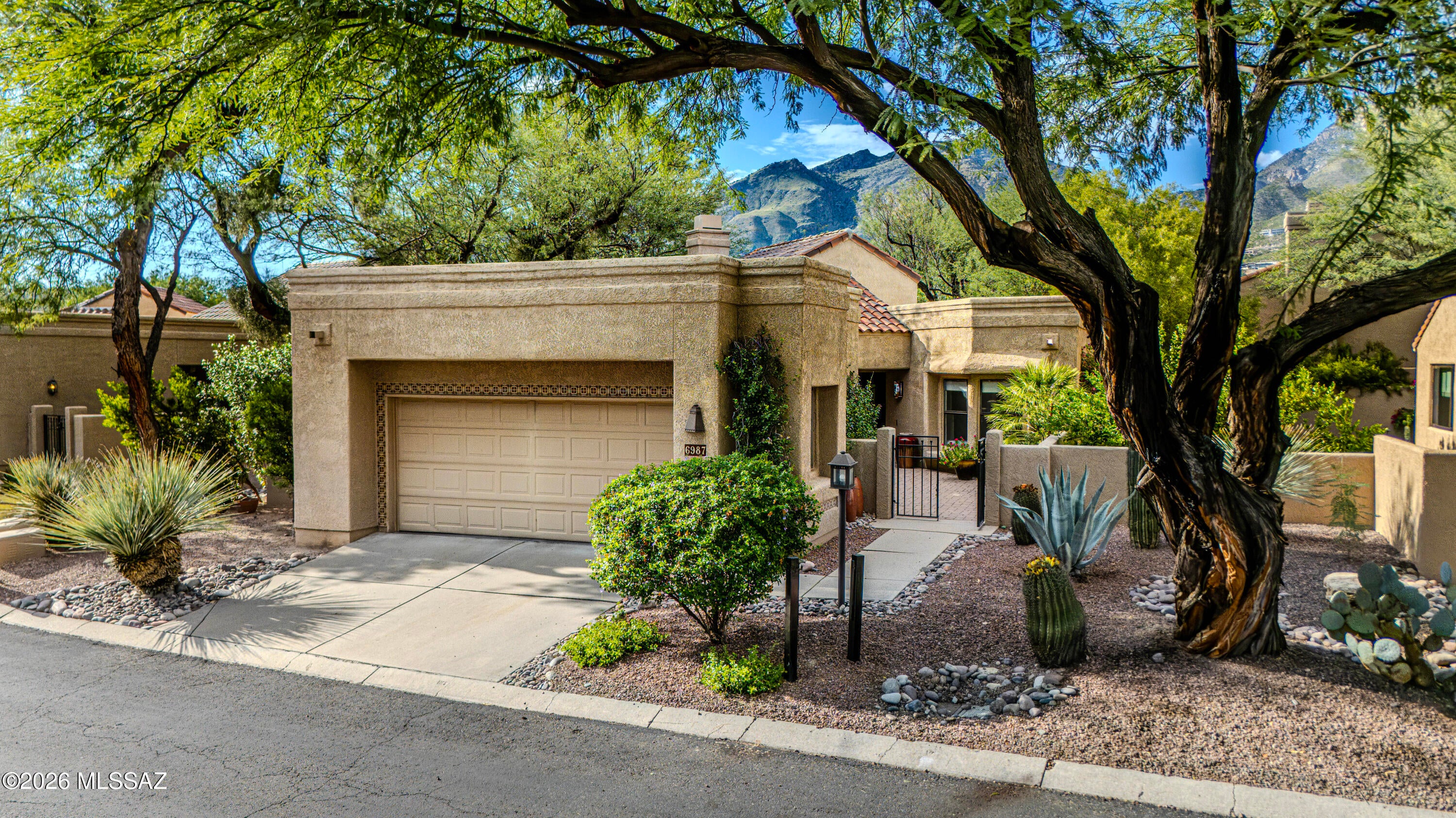 Rare Freestanding Ventana Canyon Golf Villa with Exceptional Privacy. Charming, beautifully maintained, and thoughtfully updated, this, two-bedroom, two-bathroom freestanding patio home offers an exceptional combination of privacy, comfort, and effortless indoor-outdoor living. Enjoy a peek-a-view of the golf course and a uniquely peaceful setting within the lushly landscaped Ventana Canyon Golf Villas. 

A private courtyard entry welcomes you into an inviting living space with soaring vaulted ceilings, clerestory windows, and a striking fireplace with dry bar. Pella sliding doors throughout the main living areas open to expansive side and rear patios, creating a seamless connection between the indoors and the beautifully landscaped surroundings. 

The light-filled dining room features two walls of sliding glass doors, while the spacious kitchen has been freshly painted white and enhanced with new countertops and backsplash, updated appliances, and a charming breakfast nook. The generous laundry room includes a washer and dryer, and the breakfast nook's two walls of sliding doors provide direct access to the side patio. 

The covered rear patio is ideal for relaxed outdoor living and entertaining, with an additional awning providing shade when desired. The patio wraps around the side of the home, offering abundant outdoor living space and convenient access. 

The spacious primary suite features two sets of sliding patio doors opening directly to the rear patio. The beautifully remodeled primary bath offers a walk-in shower, double vanity, and large walk-in closet. The second bedroom is thoughtfully appointed with double doors and a comfortable built-in bench with storage. A skylight fills the recently remodeled hall bath with natural light, complementing its walk-in shower. 

Recent improvements add to the home's comfort and peace of mind, including a high-efficiency AC unit replaced within the past year, a new water softener system, and significant roof maintenance. The roof has been replaced beneath the existing tile, and the flat roof has been recoated. 

Privacy is one of this home's most compelling features. Unlike many Golf Villas residences, this property is freestanding, with two sides bordering green space rather than neighboring homes. The absence of direct neighbors along the patio sides creates an especially rare sense of seclusion and tranquility. 

Residents enjoy convenient walk-across-the-street access to a pristine community pool and the beautifully maintained landscaping for which the Golf Villas are known. Situated within the prestigious gated and guarded Ventana Canyon community, the property also offers access to the many amenities and offerings of the Ventana Canyon Club for those who choose to join. Club membership is not required. 

A truly special opportunity to enjoy the privacy of a freestanding home, generous indoor-outdoor living, numerous thoughtful updates, and the exceptional lifestyle and setting of Ventana Canyon.