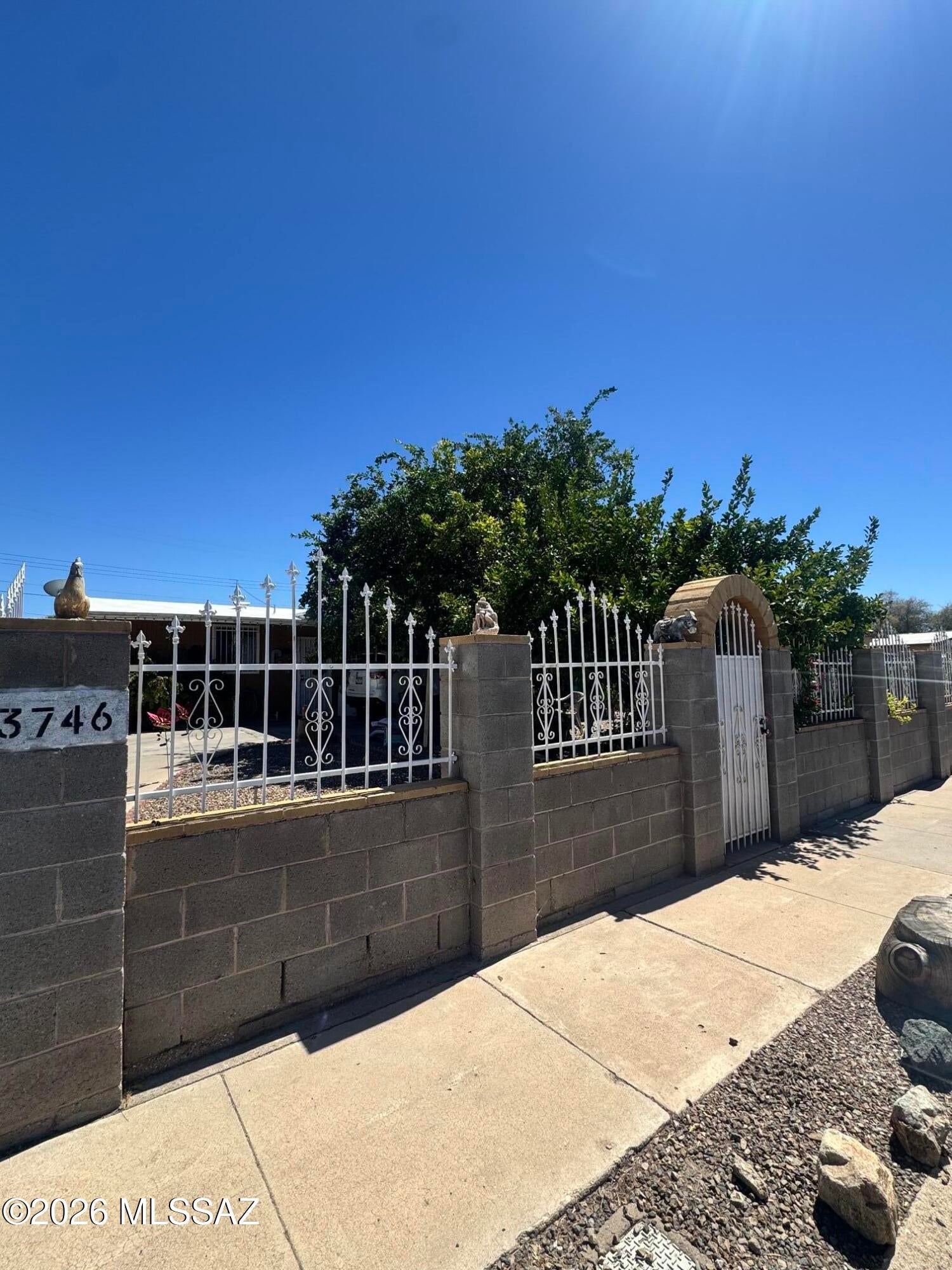 Discover the potential of this 3 bedroom, 2 bath, centrally located home that provides a functional layout, connected carport and plenty of additional parking space for everyday convenience. Step outside to a low maintenance backyard with decorative gravel, block wall fence and a covered patio that extends from end to end. Established lemon and grapefruit trees add a unique touch to the exterior. The custom wrought iron fencing enhances the home's curb appeal and the additional storage space offers the space you need. Conveniently located near major shopping centers, grocery stores, Reid Park, and Reid Park Zoo, this home offers comfort, convenience, and plenty of possibilities. Bring your vision and personal touches to make this Tucson property your own!