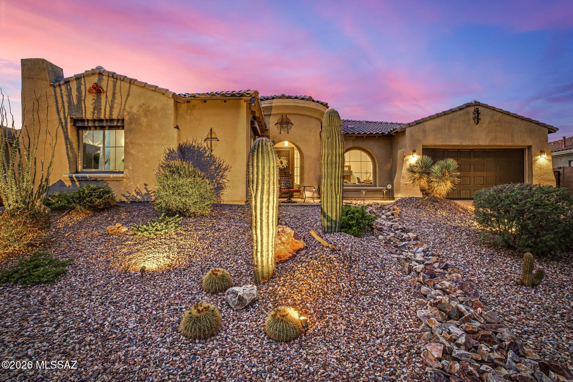 Welcome to 13511 N Trailing Indigo Court, an exceptional single-level home within the gated Center Pointe Vistoso community in Rancho Vistoso. Built in 2018, this spacious 3,679 sq. ft. residence offers an open floor plan, beautiful views of the Catalina Mountains and Mount Lemmon, soaring ceilings, custom tile throughout, upgraded window treatments, and an enhanced great room. The kitchen is designed for everyday living and entertaining with maple cabinetry, granite countertops, an extended island with generous seating and prep space, stainless-steel appliances, double ovens, a five-burner gas cooktop, upgraded faucet package, and convenient pot filler. A standout feature is the dedicated theater/bonus room, which was built as finished living space in an area where the original floor plan offered the option for additional garage space. Designed with sound-reducing drywall, a soundproof door, and rolling security shutters for room darkening and heat reduction, this versatile room can serve as a home theater, game room, fitness area, home office, art or music studio, hobby room, or other flex space. Outdoor living includes an extended covered back patio with ceiling fans, an outdoor TV mount with CAT wiring, and a natural gas connection for grilling. The professionally landscaped front yard features an extended porch and expanded brick paver areas, including a seating area positioned to enjoy the Catalina Mountain and Mount Lemmon views. A double gate provides convenient backyard access, and a standalone spa offers a relaxing place to enjoy the Arizona lifestyle. Additional features include an EV charger in the tandem 3-car garage, leased solar, rolling shutters in the guest en-suite, a whole-home wired alarm system, water softener, ceiling fans throughout, and three iron security doors/gates. Ideally located in Oro Valley, this distinctive home brings together mountain views, generous indoor and outdoor living spaces, and exceptional versatility.