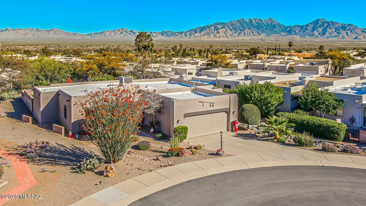 Stunning Custom Home on Over 1/3 Acre in Desirable Portillo Hills II! Welcome to a truly special property that blends custom finishes, thoughtful upgrades, and breathtaking outdoor living. Perfectly situated on a spacious over 1/3-acre lot, this beautiful 3-bedroom, 2-bath home offers style, comfort, and exceptional attention to detail throughout.From the moment you step inside, you'll be captivated by the warmth of beautiful Saltillo tile flooring, elegant Anderson windows, and wood plantation shutters throughout. The inviting living and dining area features high ceilings and a stylish modern light fixture, creating the perfect space for entertaining. At the heart of the home is the tastefully remodeled kitchen, designed to impress with granite countertops, rich hickory cabinetry with with convenient pull-out shelves, a modern backsplash, and stainless steel appliances, including a Bosch convection gas range and ultra-quiet dishwasher. A charming farm-style sink with a touch-on/off faucet adds both style and functionality. The kitchen opens to a charming breakfast nook, the perfect spot to enjoy your morning coffee. The expansive family room with a cozy gas fireplace offers a welcoming space ideal for entertaining, relaxing, or enjoying quiet evenings at home. The owner's suite offers a peaceful retreat with a walk-in closet and an en-suite bathroom featuring dual sinks and a beautifully remodeled walk-in shower. Two additional bedrooms provide flexibility for guests, hobbies, or a home office. The guest bathroom has also been remodeled and includes a walk-in shower. Step outside to your own private backyard oasis, where you can relax under the pergola while enjoying beautiful sunrise views. The thoughtfully landscaped yard features elegant pavers, a stunning water fountain, mature citrus trees, and a three-zone Rain Bird irrigation system--enhancing both the beauty and privacy of this impressive outdoor setting. The extended yard space beyond the wall has also been professionally landscaped, adding even more space and visual appeal to this exceptional backyard retreat. The two-car garage offers abundant storage with overhead racks, storage cabinetry, a Rubbermaid FastTrack storage system, and even space for a workshop. Additional upgrades include a custom wrought iron front screen door, HVAC and water heater only 8 years old, water softener, roof recoated in 2025, newer insulated garage door and motor, low-voltage landscape and accent lighting and much more. Take advantage of the Green Valley Membership  that provides access to pools, fitness centers, classes, shows, and a wide variety of amenities. A truly one-of-a-kind property that combines charm, quality, and comfort--this is a home you don't want to miss!