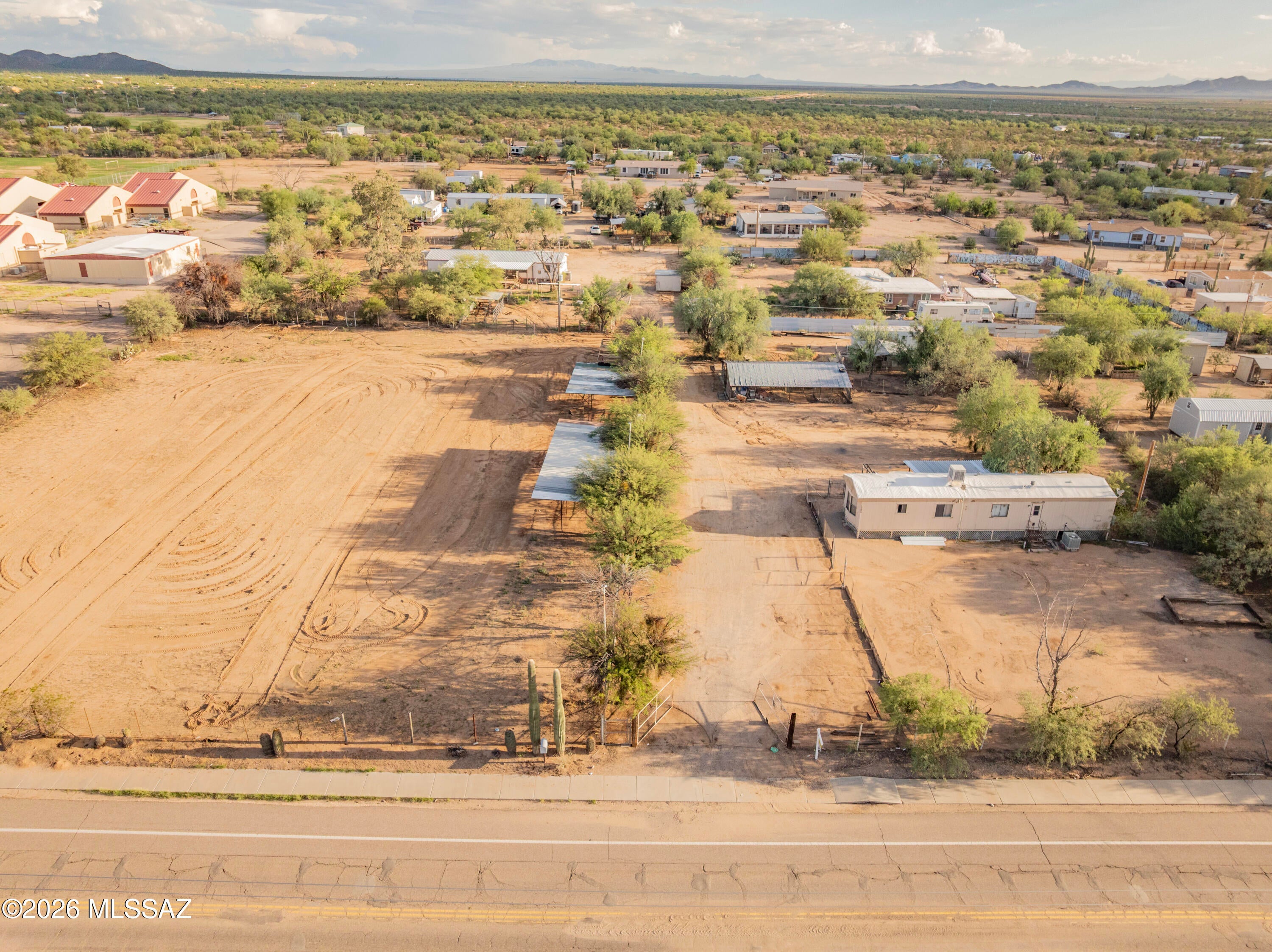 Horse property with endless possibilities in the heart of Picture Rocks! Bring your horses and ideas to this unique 3 acre property featuring two adjacent lots, two manufactured homes, and an established equestrian setup. Horse corrals, a huge horse arena, pole barn, chicken coop, animal pens, sheds, & more! All on a paved road near the elementary school & community center! The main doublewide at the back offers an open living area & split-bedroom floorplan with lots of potential. The second singlewide at the front of the property is unaffixed and offered as-is at land value. Live in one home and rent the other, create a multigen setup, or build a new home & your dream horse property! Space & zoning may allow a third home; buyer to verify. Upgraded septic sized for future 4-5 BR home. Neighborhood community center features pool, splashpad, playground, & more! Just minutes from Saguaro National Park in peaceful Picture Rocks community. Several custom homes have recently been built up & down Rudasill Rd for buyers looking to build.  Live in one and rent the other(s)!
