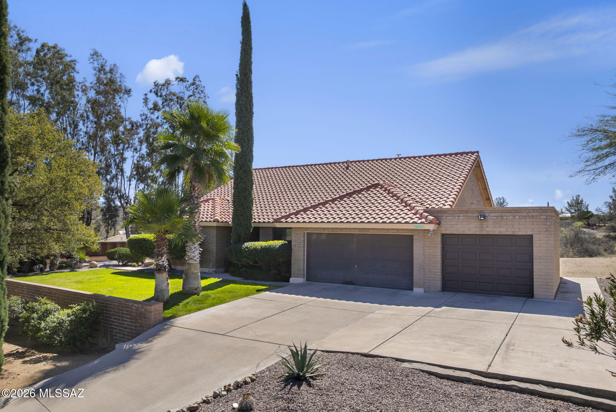 Welcome to this beautifully maintained home located in a quiet neighborhood in the heart of Nogales. Situated on an expansive 0.55 acre lot, this 1,843 sq ft residence offers space, comfort, and pride of ownership throughout. The exterior welcomes you with mature landscaping, large shade trees, decorative rock, lush green grass, and palm trees, creating a serene and inviting setting. Built with durable slump block construction, the home also features a tile roof, chimney, custom wrought iron doors, and a spacious 3-car garage with additional storage. The generous lot provides ample parking and room for multiple vehicles or recreational equipment. Inside, the home is exceptionally well kept and thoughtfully designed. Enjoy a bright living room, formal dining room, and a comfortable family room, perfect for everyday use or entertaining. The spacious kitchen features granite countertops, a center island, and stainless steel appliances, making it both functional and stylish. All bedrooms are generously sized, including a primary suite that offers space for a cozy sitting area. The primary bathroom features double vanities, a large walk-in shower, a relaxing soaking tub, and a walk-in closet. Step outside to a covered back patio where you'll find a private, peaceful backyard with low maintenance landscaping and a large concrete pad ideal for gatherings. The yard is fully gated for added privacy and peace of mind. An additional highlight is the approximately 450 sq ft fully equipped sunroom, offering endless possibilities. This versatile space can be used as a home gym, outdoor kitchen, entertainment area, or greenhouse. With beautiful front views, a spacious lot, and a central location in town, this home offers the perfect blend of comfort, privacy, and convenience.