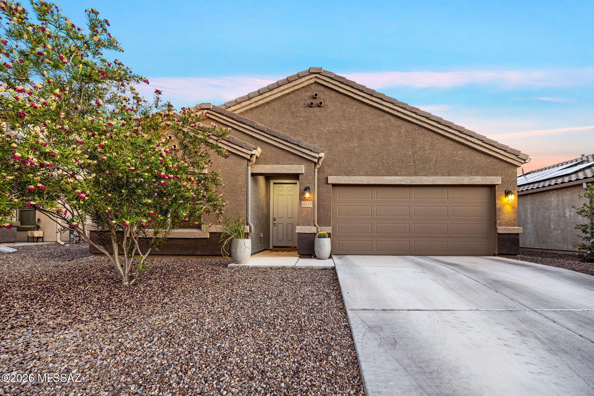 This beautifully appointed four bedroom, three full bathroom home with a den is designed for modern living and effortless entertaining. This open spacious floor plan features stunning ceramic wood-looking tile throughout the main living areas and carpeted bedrooms for comfort. The heart of the home is the well-equipped kitchen, showcasing premier stainless steel appliances, ample cabinetry, and generous counter space that seamlessly connect to the living and dining areas. Retreat to the spacious primary suite with luxurious ensuite and oversized walk in closet. Enjoy three additional bedrooms and a versatile den plus two additional bathrooms for guests,  hobbies or family. Step outside to a large, low-maintenance backyard with no rear neighbors, creating a private setting perfect for relaxing, entertaining, or simply enjoying Arizona's beautiful sunsets. With its thoughtful upgrades, functional layout, and desirable location, this home offers the perfect blend of style, comfort, and convenience.