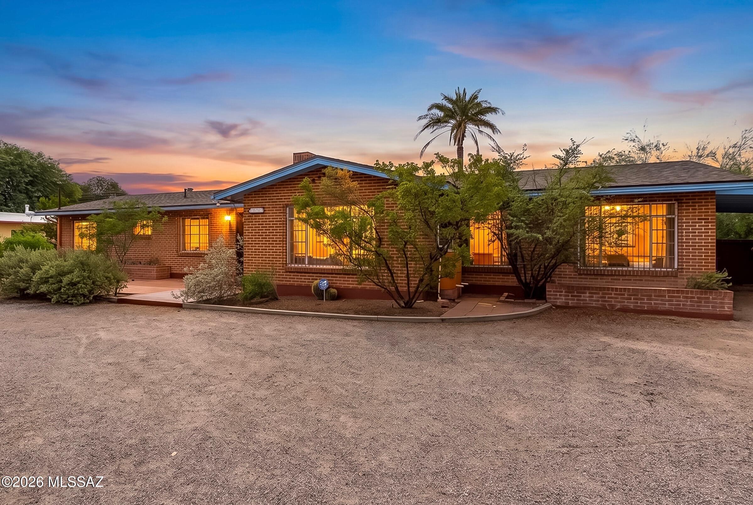 A rare confluence of vintage style and functional spaces, this midcentury brick ranch offers thoughtful updates. This designated historic residence in the coveted Wilshire Heights neighborhood honors the original character of the period while accommodating a host of capacities.  The inviting 4-bedroom & 2-bathroom plan has not only an additional office space and den, but also a cozy flex space beyond the large living and dining room. Saltillo and complimentary ceramic tile flow throughout the home, while  colorful accent finishes accompany bathrooms and a cozy fireplace. The well crafted kitchen offers stainless appliances, granite countertops, and a large walk in pantry that is perfect for a coffee bar or copious storage. Additional upgrades include a gorgeous hall bath, fresh interior paint, and a brand-new roof with transferable warranty. Outside, enjoy a generous backyard, sparkling deep pool, expansive patio and room for gardening, entertaining, and play! Parking abounds in the circle driveway & carport, or enjoy a meandering pedestrian lifestyle through the neighborhood. This peaceful, central Tucson setting is ideal for walking & biking, conveniently located near two neighborhood parks  and a short distance to Tucson Medical Center, Park Place Mall, the University of Arizona, and Davis Monthan Air Force Base.