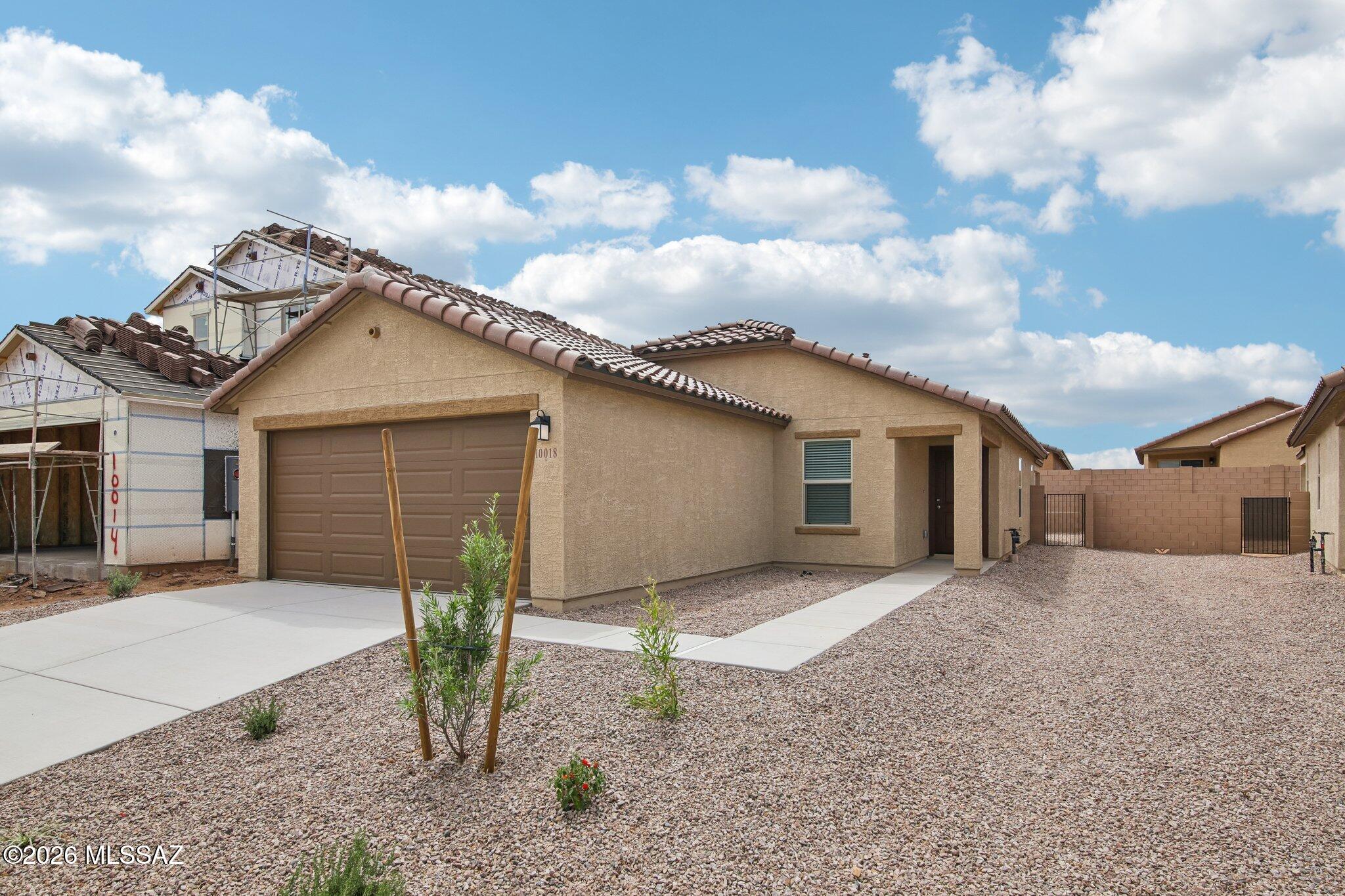 This home is open for self-guided tours daily 8 am - 8 pm. Located in a beautiful master plan near Rita Ranch, this single-story home features ceramic tile flooring, a soft water loop, and a landscaped backyard. Overlooking the spacious great room, the kitchen showcases Silestone® quartz countertops, birch cabinets, a walk-in pantry, and Whirlpool® appliances, including an electric range and dishwasher. The primary bedroom boasts a walk-in closet and adjoining bath with a dual-sink vanity and walk-in shower. Bedroom 2 includes a walk-in closet. The covered patio provides a comfortable outdoor retreat for dining and entertaining. Price includes discount predicated on using seller's preferred lender KBHS.