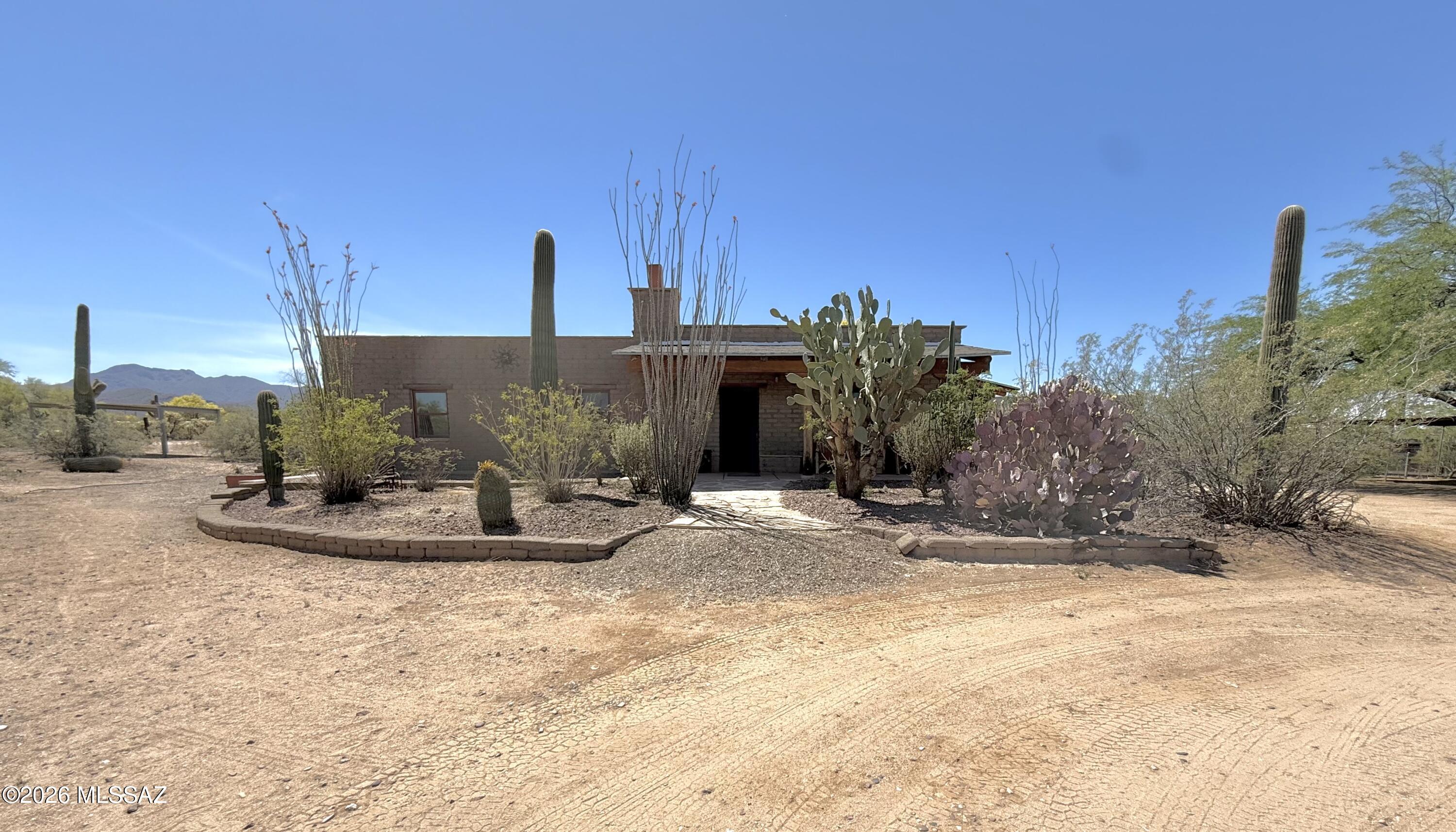 Enjoy authentic Sonoran Desert living on 1-acre, surrounded by panoramic mountain views and spectacular sunset skies. Built of true adobe brick, this special home offers natural insulation ideal for desert climates with thick, high-thermal-mass walls-keeping interiors cooler in summer and warmer in winter while delivering timeless Southwestern character. Built-in fire suppression system and ''passive solar''(No equipment needed). Enjoy 2 bedrooms, 1 bath, plus a versatile office/flex room. The property includes a 2-car carport, workshop/storage room, two mobile-mini storage containers, and covered shade for horses. With tunning scenery, and timeless Southwestern character, this unique adobe retreat offers comfort, efficiency, and authentic desert living. Neighboring the Saguaro Nat'l Park,