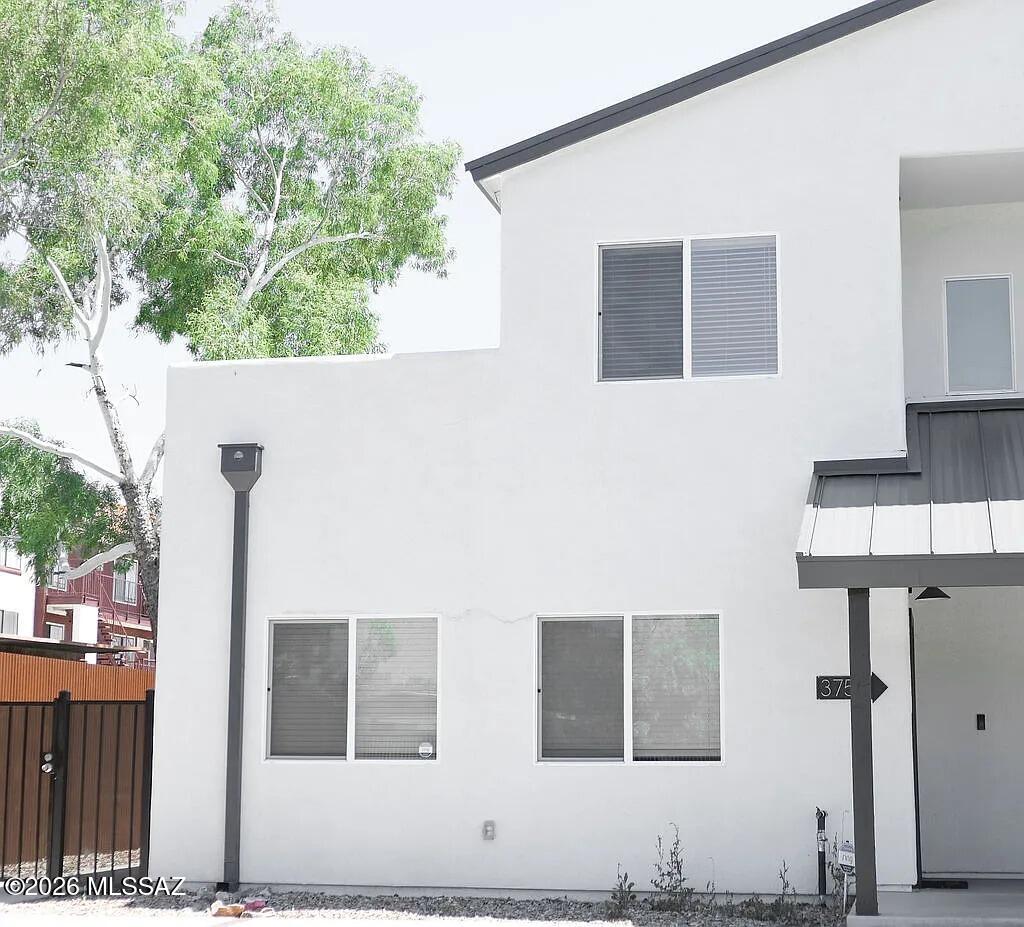 Move-in ready and built in 2022, this Central Tucson townhome offers 3 bedrooms, 2 full baths, and 1,490 sq ft in a thoughtfully designed two-story layout. The split-bedroom floor plan features a spacious primary suite on the main level, with two additional bedrooms upstairs. The great room flows into a kitchen with granite countertops, a center island with breakfast-bar seating, stainless-steel appliances, and a convenient laundry closet. High ceilings, ceiling fans, energy-efficient lighting, and a mix of laminate and carpet add comfort and style throughout. The primary bath features dual vanities. Outside, enjoy mountain views, low-maintenance landscaping, and durable metal fencing. Modern, comfortable, and easy to maintain, this home is ready to welcome its next chapter.