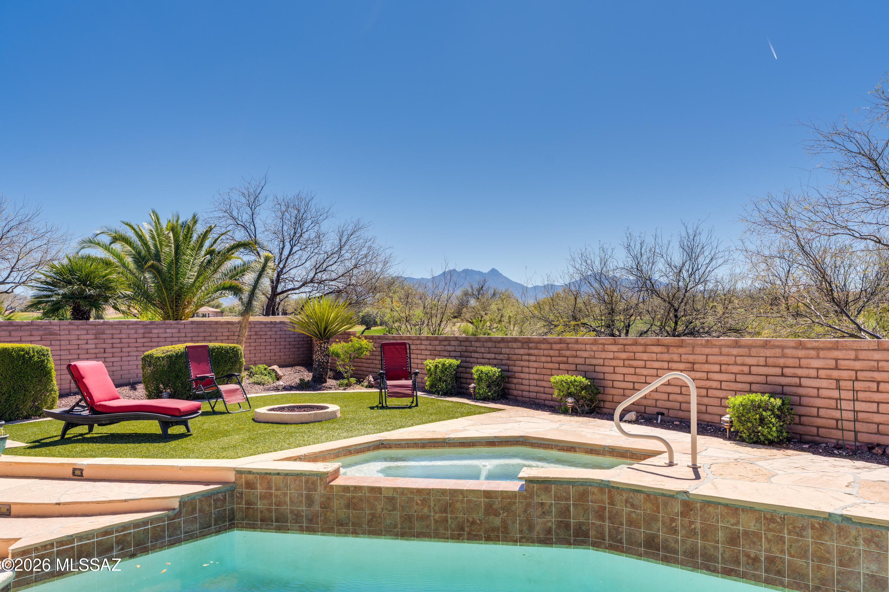 This spacious 3 BR, 2.5 BA Cheyenne model offers 2,793 sq.ft, and the perfect blend of comfort, functionality, and indoor/outdoor living. Featuring a pool, spa, fire pit, mountain views, owned solar, and a separate workshop/studio, this is truly a home that has it all. A well-defined front courtyard and impressive 8' entry door welcome you into the foyer, which opens to formal living and dining rooms, ideal for entertaining. A convenient wet bar connects the formal and informal living spaces, creating great flow for gatherings. The spacious family room features a cozy gas fireplace and media wall, and opens to the kitchen and casual dining area. The chef's kitchen is designed for everyday living and entertaining, showcasing granite counters, gas cooktop, wall oven and microwave, island with breakfast bar and pendant lighting, and a desk for organizing household tasks.The owner's suite includes a bay window, two walk-in closets, and a luxurious bath with dual vanities, jetted tub, and separate tile shower. The split bedroom plan provides privacy with two guest bedrooms, a full guest bath, and a powder room for visitors. A large versatile den/office features built-in desks, bookcases, and a wall bed, making it ideal as a workspace or optional fourth sleeping area. Enjoy outdoor living year-round from the large end-to-end covered screened porch, overlooking a resort-style backyard. Spend warm Arizona days in the heated pool with waterfall and spillover spa, and cool evenings around the gas fire pit, all surrounded by low-maintenance artificial turf and open views of the Santa Rita Mountains with no rear neighbors. The backyard also includes a separate 389 sq.ft.workshop/studio with adjacent storage and loft, perfect for hobbies, projects, fitness, or creative space, plus a BBQ area for outdoor entertaining. The home is equipped with an owned 10 kW solar system, providing energy efficiency and long-term savings. New roof in 2023, and 2 new HVAC units in 2018. A rare Cheyenne model with premium upgrades, privacy, and exceptional outdoor amenities in Quail Creek.