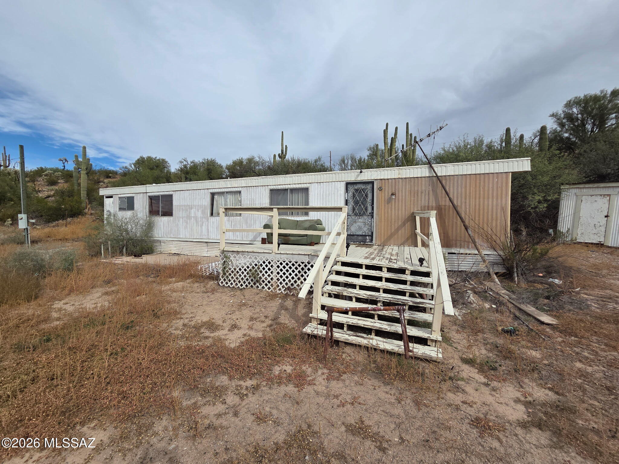 Discover the potential of rural Arizona living in Dudleyville! This 1-acre property features a 2-bedroom, 2-bath manufactured home with approximately 1,400 sq ft, served by a water company and sewer. This is a true fixer-upper and an excellent opportunity for someone looking for an affordable property to renovate and make their own. Enjoy the peace and quiet of a rural setting while remaining conveniently close to nearby amenities. Winkelman is approximately 5 miles away and offers gas, a convenience store, restaurant, and K-12 school. Kearny, about 10 miles away, provides grocery shopping, healthcare, chiropractor, salons, library, swimming pool, restaurants, and a small airport. Bring your vision and transform this property into your Arizona retreat!