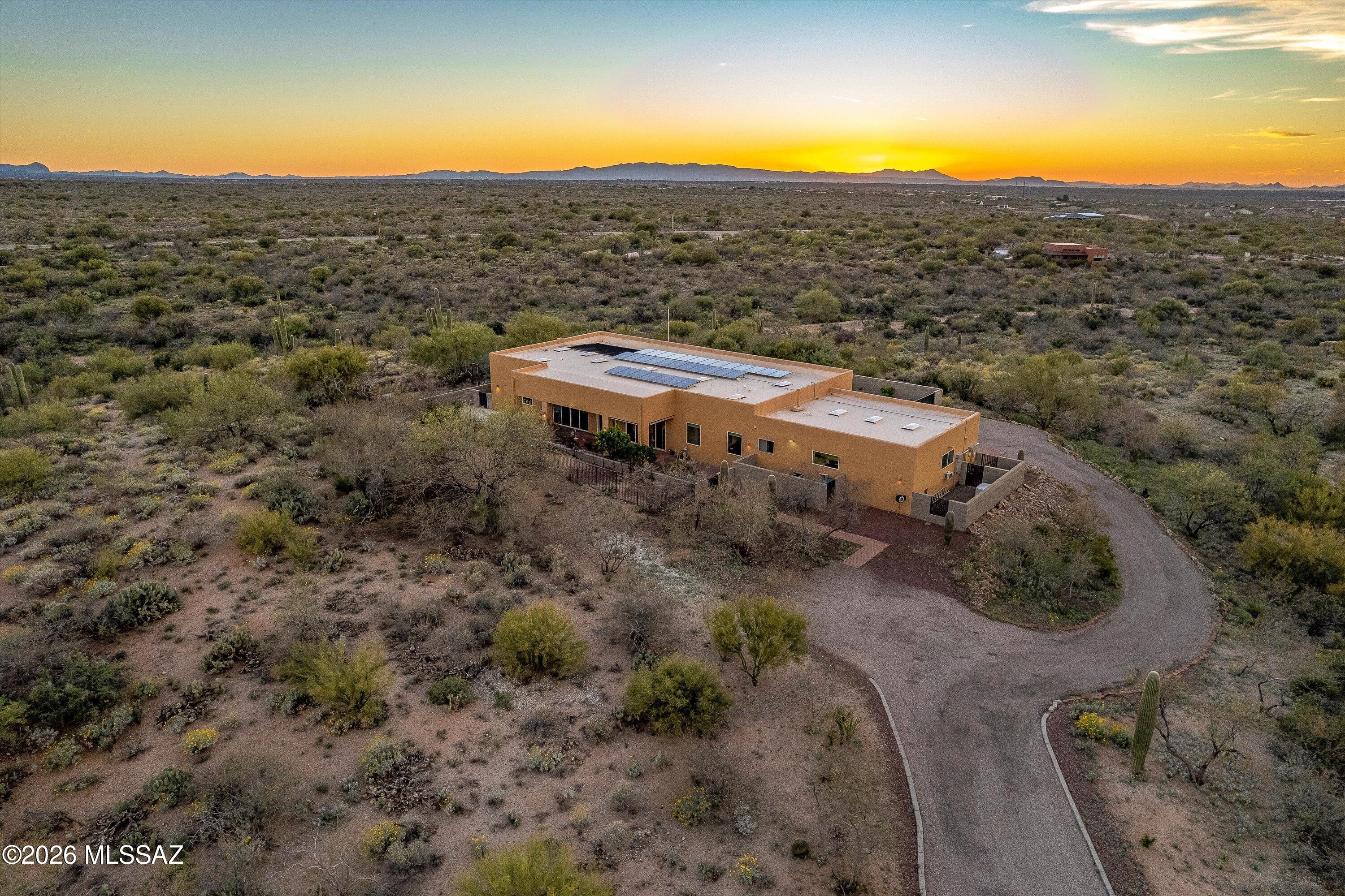This contemporary home sits on 2 acres and offers jaw-dropping views of the Rincon Mountains and ranges beyond. Custom built in 2005, the open-concept design features a massive 30' x 40' great room with 54' of glass, a striking see-through fireplace, and a flowing split-bedroom floor plan ideal for effortless living and entertaining. 
Two Full length, 10' wide brick verandas extend the living space outdoors, offering breathtaking 360-degree views of the Tucson valley and surrounding mountains. Nestled in the Sonoran Desert, Coyote Creek features walking paths throughout and community amenities nearby - making this home the perfect blend of modern design, comfort, and Arizona beauty.