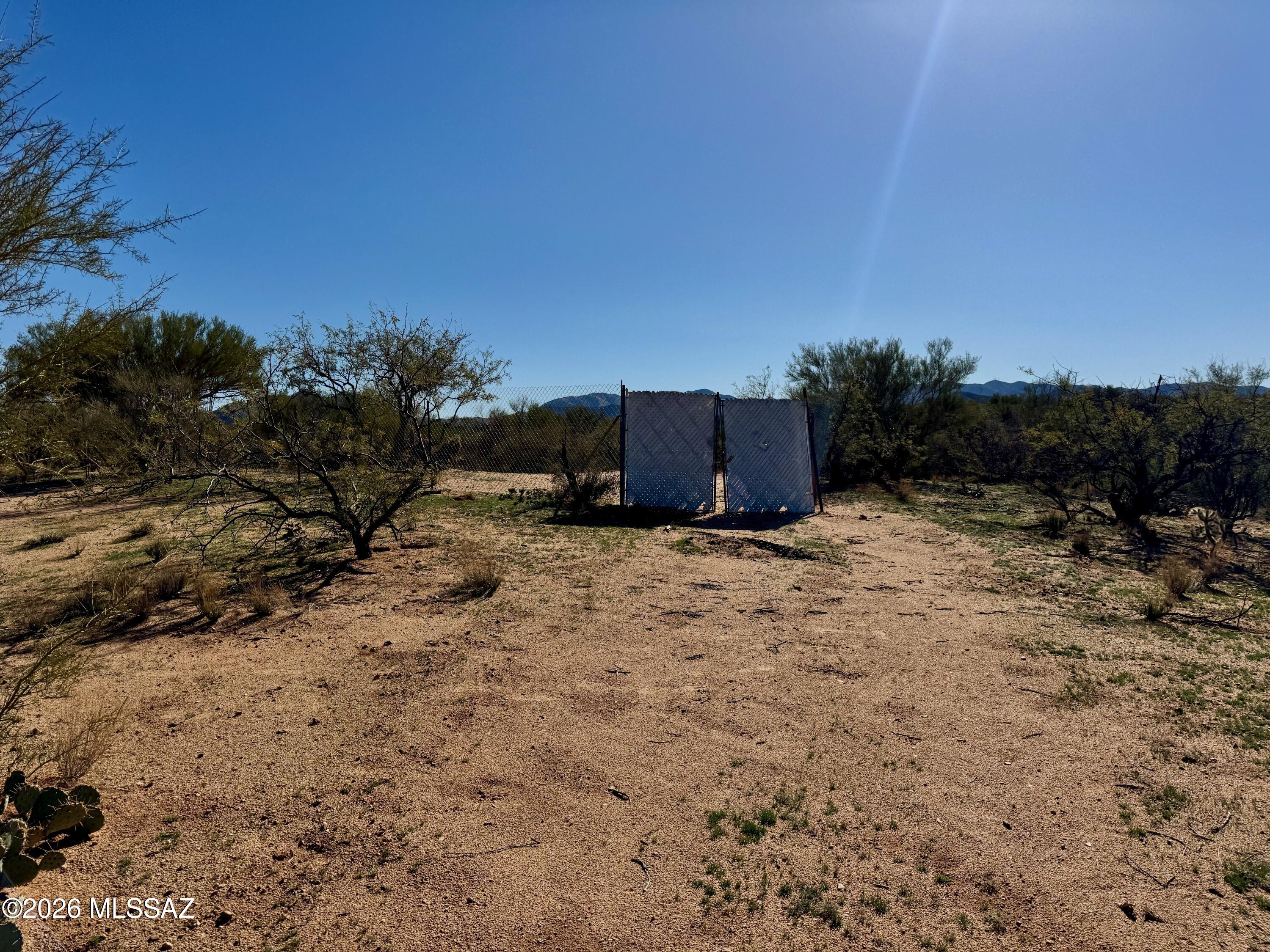 This is an elevated lot with a fenced area that is cleared out ready for your recreational weekend fun! Or live in the fenced area with your RV while you have a building permit for up to 1 year! The county may extend if it takes longer to build. Single family homes only allowed on CR1 zoned lots. Directly across the street from 640 plus acres of Arizona State Land. Utilities are about a mile away. Make your off grid paradise!!! Views of the Kitt Peak Observatory from your yard! Wildlife galore. Corner lot that backs up to a wash on a country dirt road. NO HOA! It dissolved years ago.