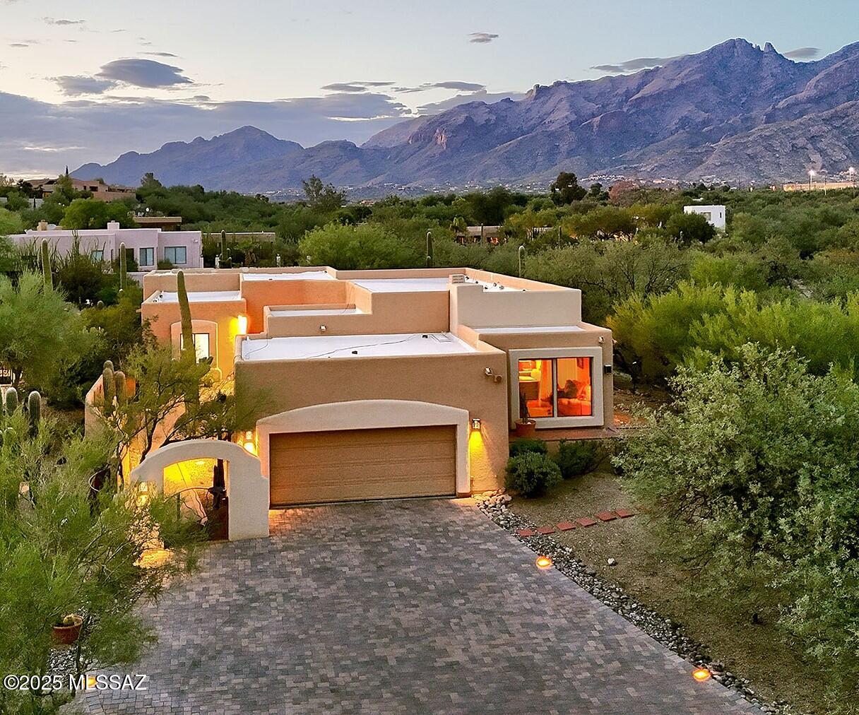 Perched high in sought-after Las Alturas, this stunning 3,226 sq. ft. residence offers refined desert living at its best. Enter through a charming, private courtyard and step into a home designed with both elegance and comfort in mind. The expansive living room boasts soaring 10-foot ceilings and walls of windows that flood the space with natural light, while the formal dining room provides the perfect setting for intimate gatherings. Newly recoated roof w/2 year warranty, newer HVAC system.  The beautifully remodeled kitchen is the true heart of the home, featuring a generous center island, breakfast bar, and eat-in area, all opening to the spacious family room or separate den, ideal for entertaining.
The split floor plan ensures privacy, with the primary suite offering a peaceful retreat complete with ensuite bathroom with jetted tub, walk-in shower, and custom walk-in closet. Step out from the suite to the covered patio and take in expansive views of the Santa Catalina Mountains. Guest quarters feature a private ensuite bath, while the additional bedrooms share a stylish hall bath.
An oversized two-car garage, custom brick pavers adorn abundant off-street parking with custom inset lighting, beautifully designed outdoor spaces complete this exceptional home.