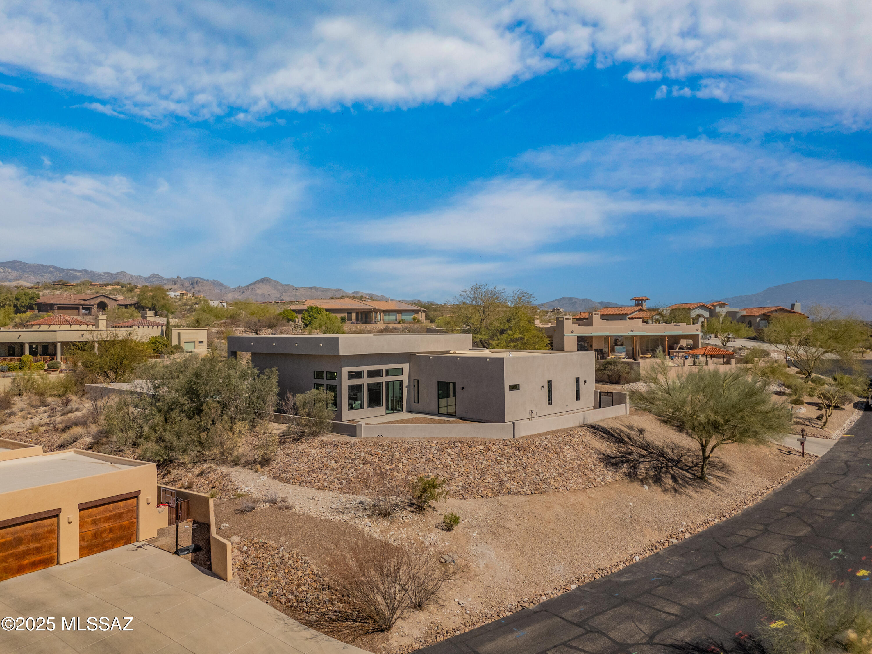 Located in the exclusive Catalina Foothills, this custom-built 4-bedroom, 6-bathroom home offers 3,587 sq. ft. of luxurious living space, plus 500 sq. ft. of outdoor living. Designed for elegance and comfort, this modern masterpiece features premium finishes and breathtaking mountain and city views.

The open-concept floor plan boasts soaring 15' ceilings and a seamless indoor-outdoor flow, enhanced by 16' sliding glass doors leading to the backyard. Enjoy a pool, spa, and an exterior bathroom, all set against a stunning mountain backdrop. A bar area with glass doors opens to a front patio with sweeping city views.

The primary suite is a private retreat with two walk-in closets, tongue-and-groove ceilings, and direct access to the patio and pool. The spa-like bathroom features