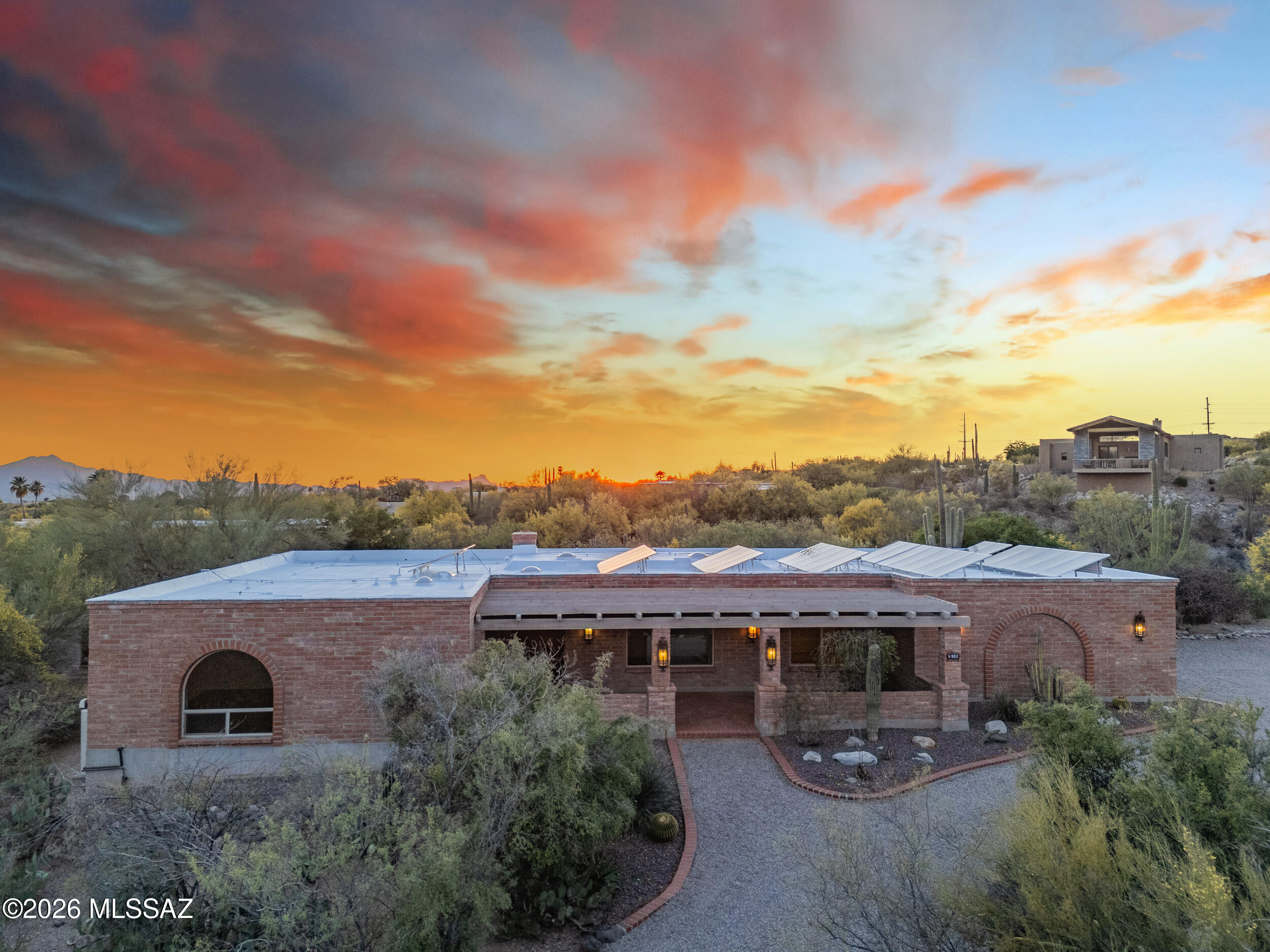 Adobe Hacienda first time on the market in 25 years! Beautiful home lovingly lived in & taken care of. Arches & brick fireplace. Space all around this private view lot boasts natural vegetation. Artificial turf & extended covered patio inside your walled yard.  Gated pool area & hot tub.
Enjoy evenings in your back yard w/an outdoor BBQ. Dine al fresco & watch the gorgeous Tucson sunsets. Circular drive welcomes you w/charming front patio. Beamed Pecky Cedar wood ceilings in the family room & handsome fireplace. Kitchen includes newer oven, micro/convection oven, sink overlooking patio & nice pantry space. Bathroom off laundry rm w/door to the outside.
Owners suite offers a dreamy picture window to enjoy the Catalina mtns. Updated vanity w/2 sinks & walk in closet. Solar is owned.