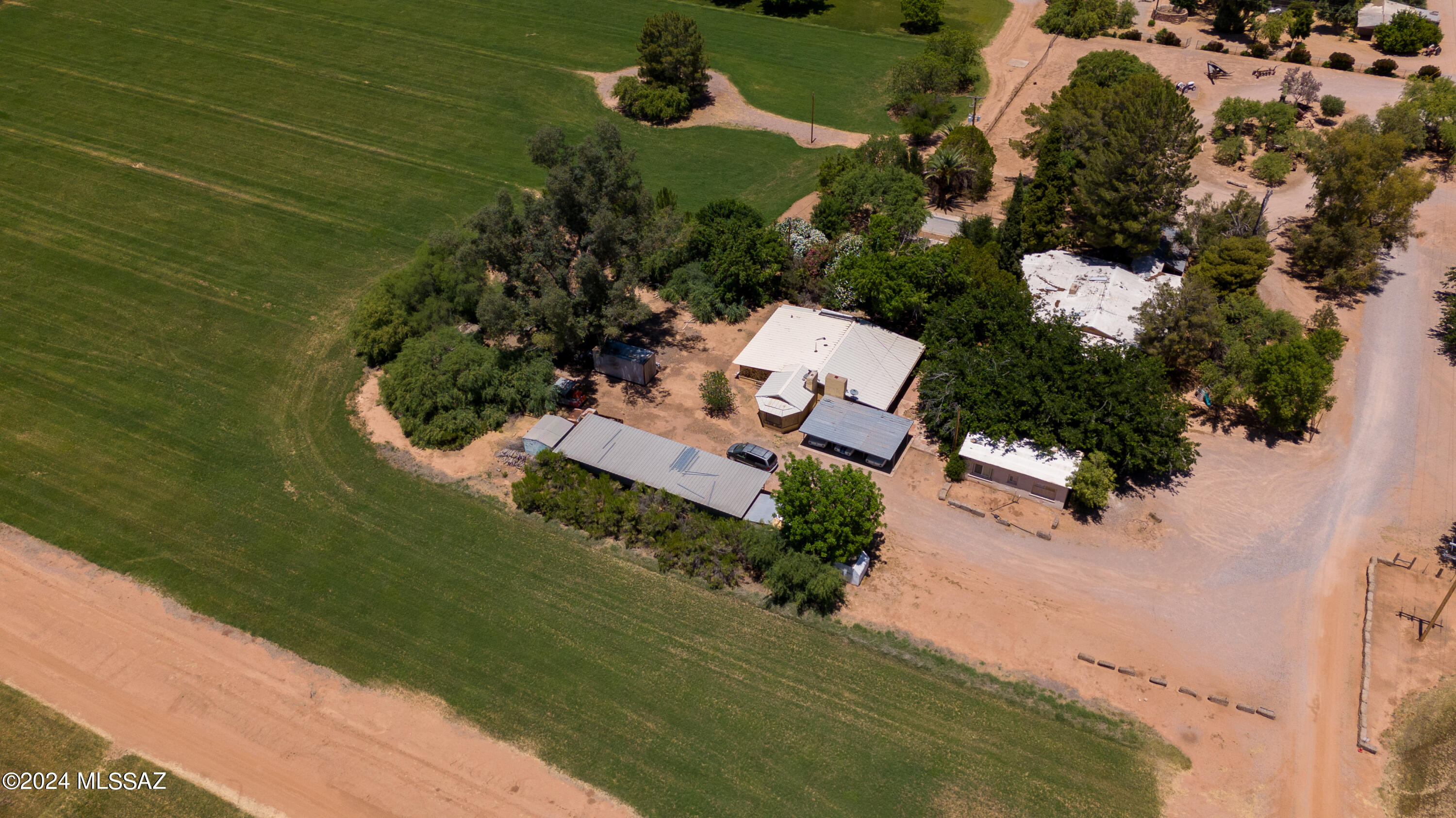 Property has never been on the market. This is a once in a lifetime opportunity!
 
Be surrounded by the awesome beauty of nature. Work and till the land. Have real relationship with life surrounding you. Live, work and play in your very own homestead amongst the trees, the water and the fields. Experience for yourself this amazing multi acre homestead with working hay farming operation, and a picturesque, rustic event and wedding venue.

If you enjoy having plenty of space to spread out and enjoy extraordinary unobstructed views of the valley's mountain ranges and spectacular Arizona sunsets, you're going to love this property. History abounds on this estate that was originally homesteaded in the 1920's.

The charming main house, nestled amongst the trees has adobe walls and wood beamed ceilings. There are multiple additional guest residences and all are all on a private well with grandfathered water rights. There are numerous outbuildings, barns and a large workshop as you would expect with such a homestead. Surrounded by fields of green farmland, currently planted and farmed with Bermuda grass (hay) all on a separate irrigation well which pumps about 600 gallons per minute! Wedding venue area included; the reception barn and surrounding area feature a large dance floor, ambient lighting, grassy area, and lush foliage for lovely photographs as well as public restrooms. There are two cozy, private casitas one for the bride and one the groom. There's so much more than words can describe, you really need to experience it for yourself!